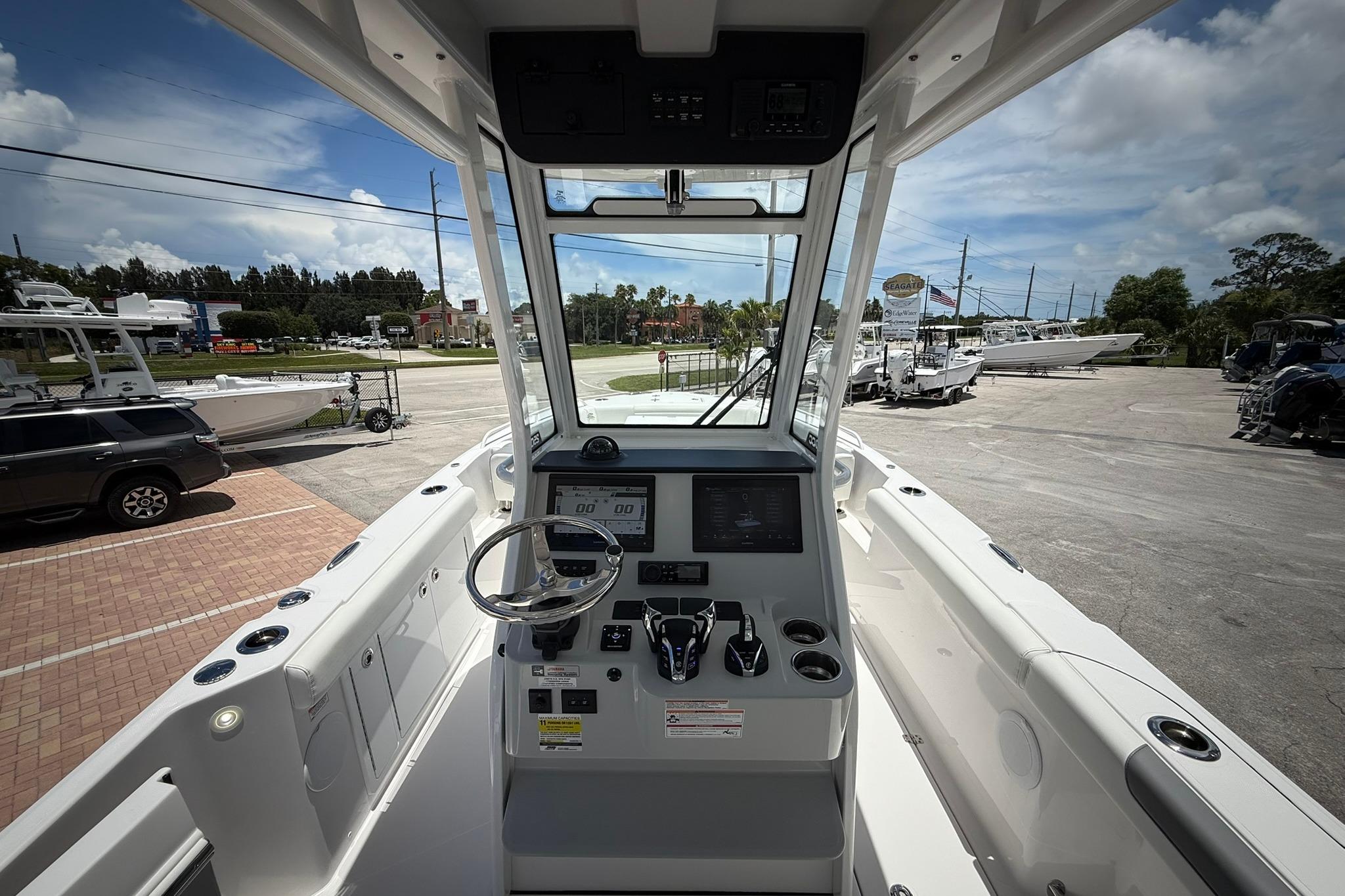 Interior view of 2026 Edgewater 250CC boat cockpit with steering wheel and control panel.