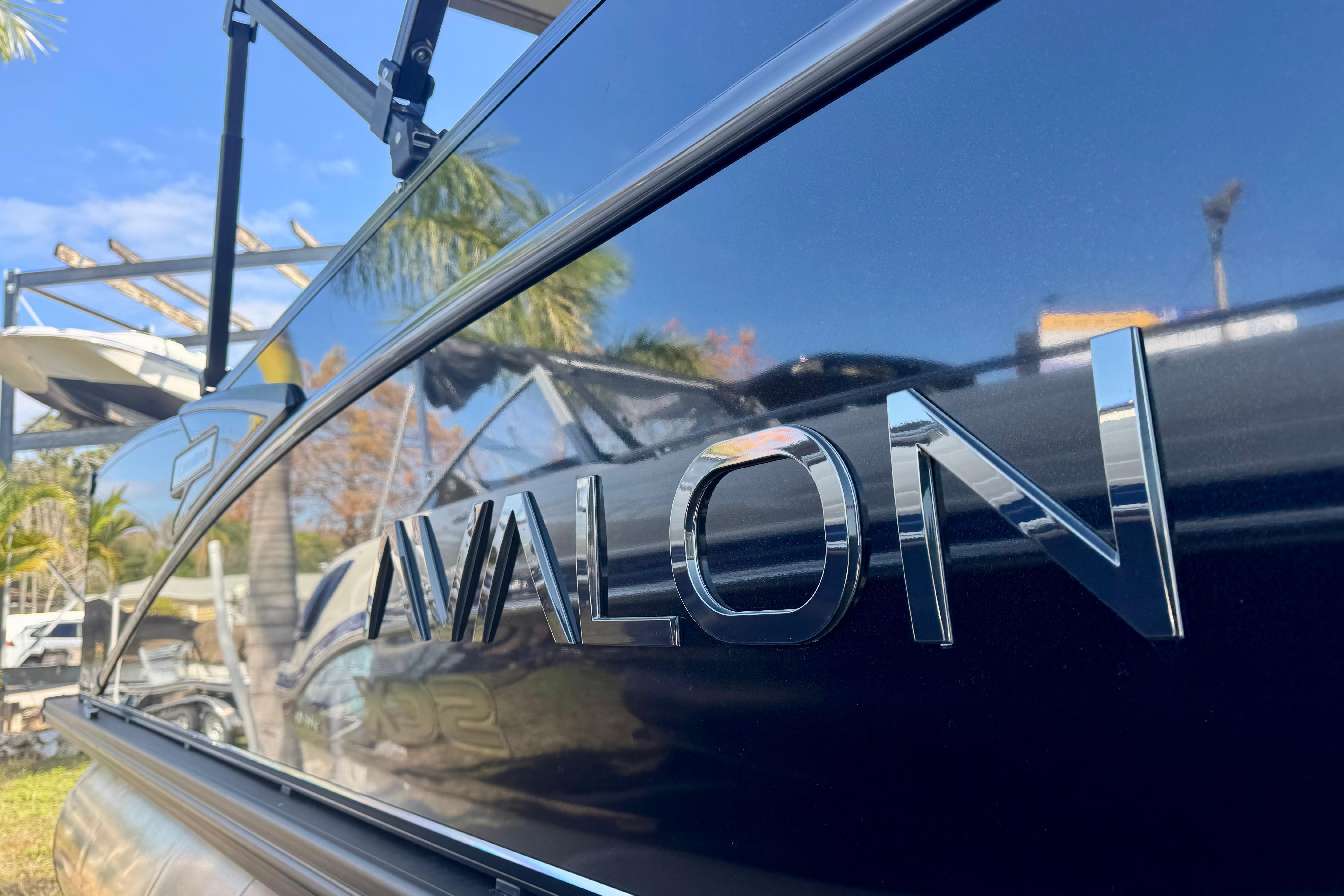 2026 Avalon Catalina Platinum Versatile Rear Bench boat with chrome logo, reflecting sunny surroundings.