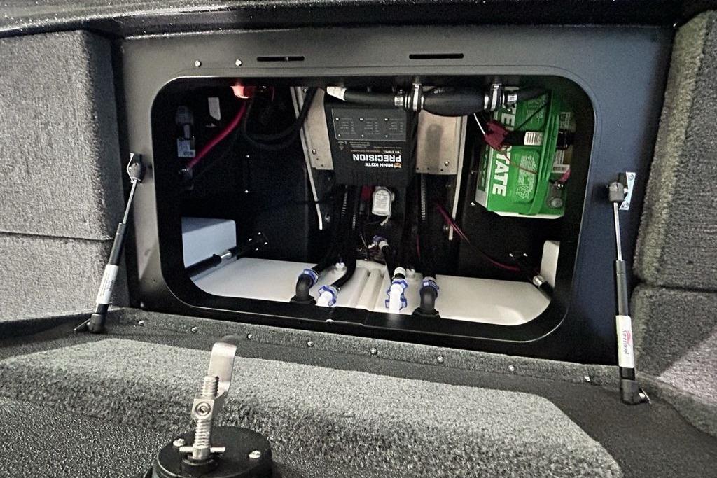 Open compartment of 2026 Skeeter ZX200 boat showing battery and wiring setup.