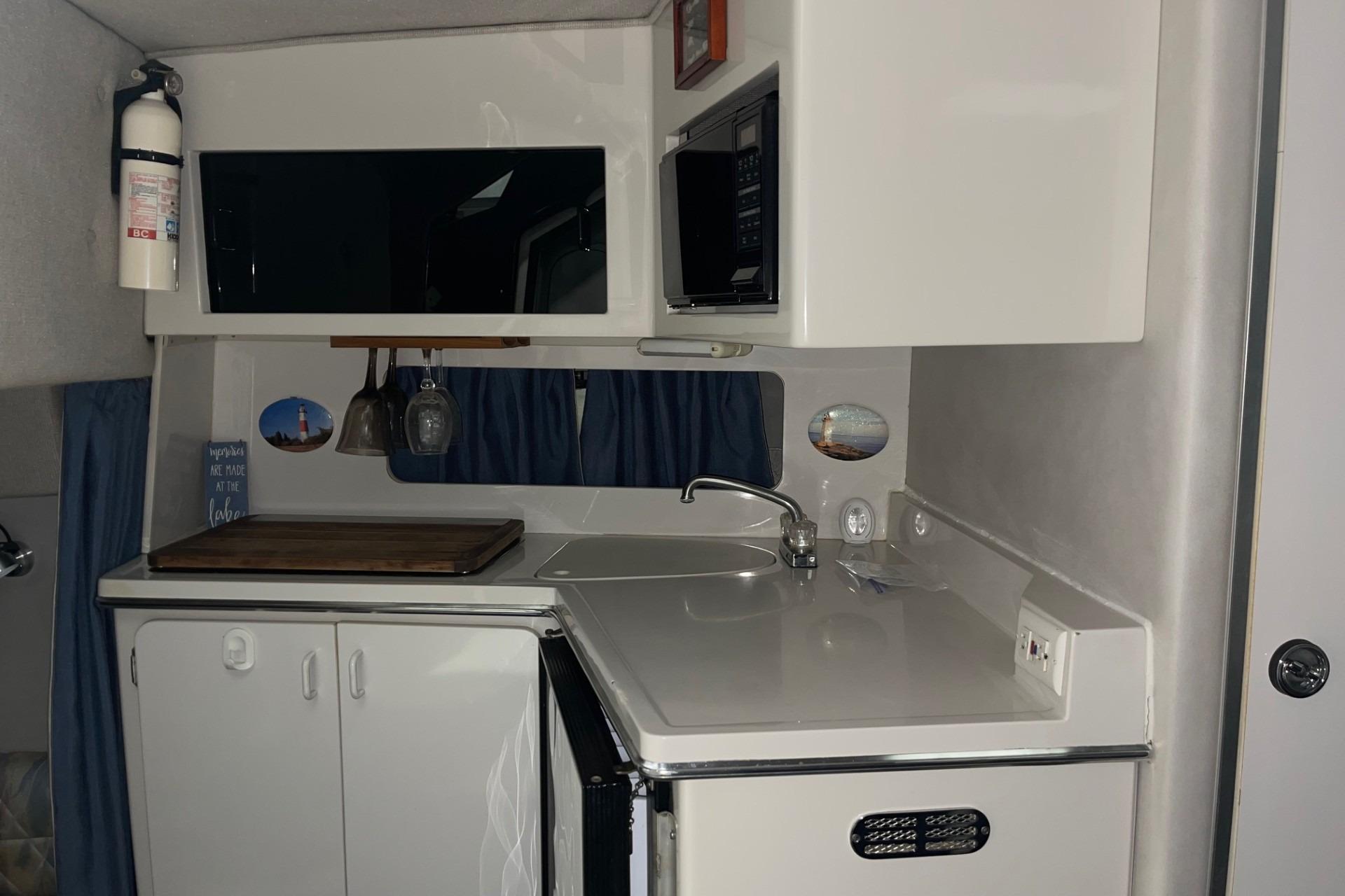 1992 Chaparral Signature 30 boat kitchen with sink, cabinets, and microwave.
