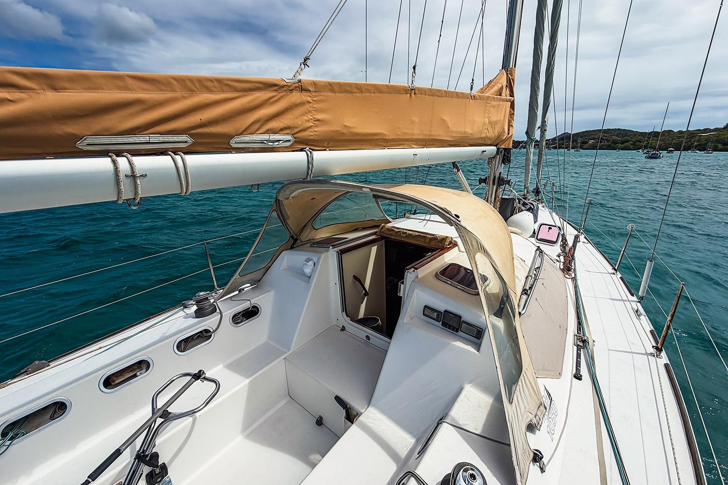 Sailing yacht RM Yachts 1050, 2006 model, on turquoise waters under a cloudy sky.