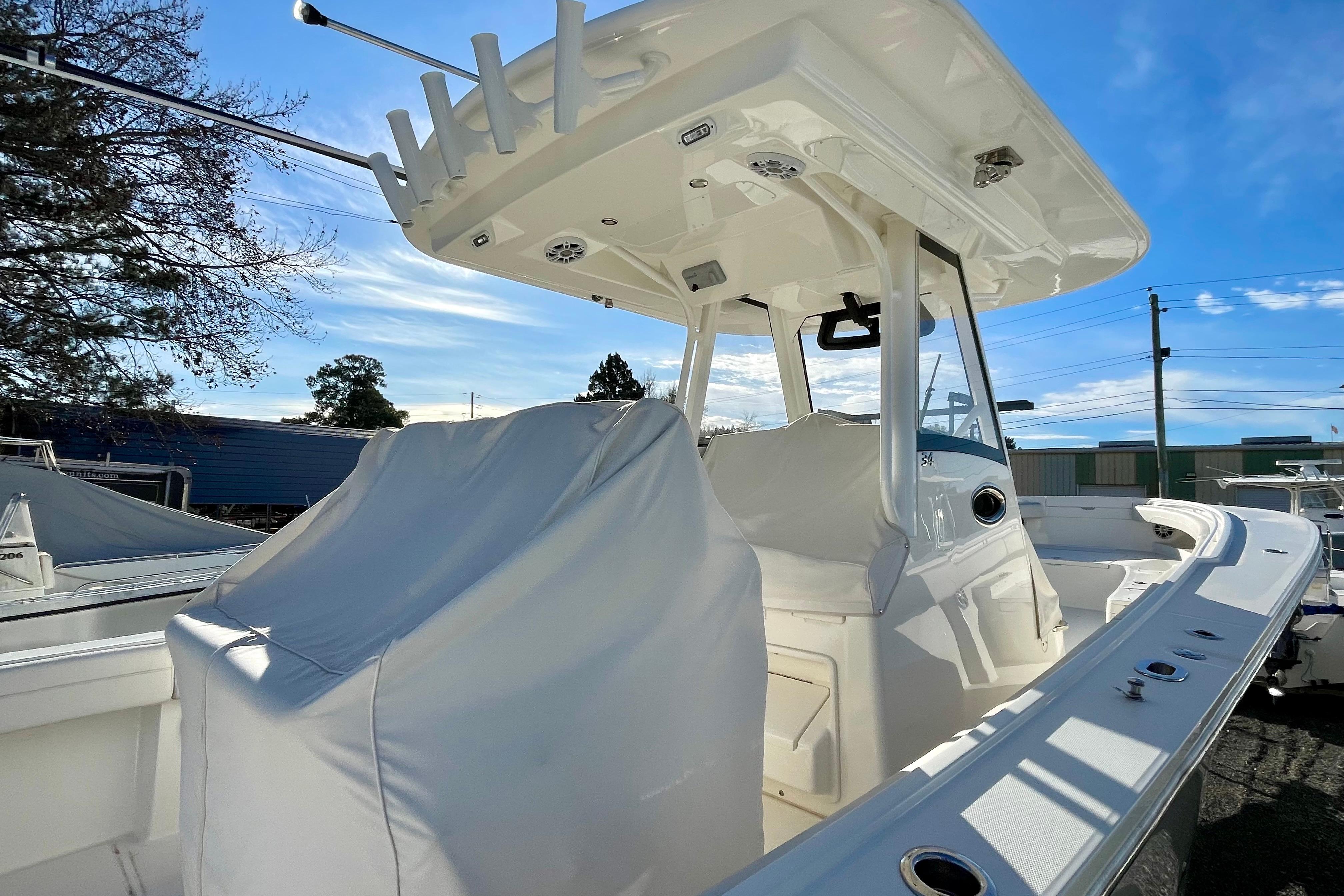 2023 Regulator 34 boat with covered seating and T-top under a clear blue sky.