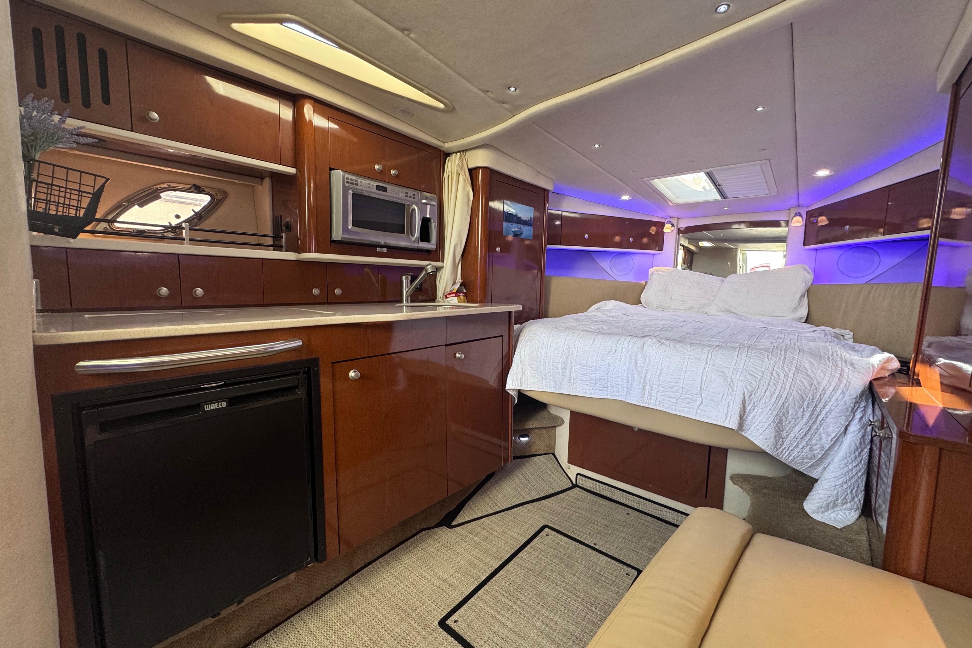 Luxurious interior of 2008 Sea Ray 350 Sundancer yacht with kitchenette and cozy bed.