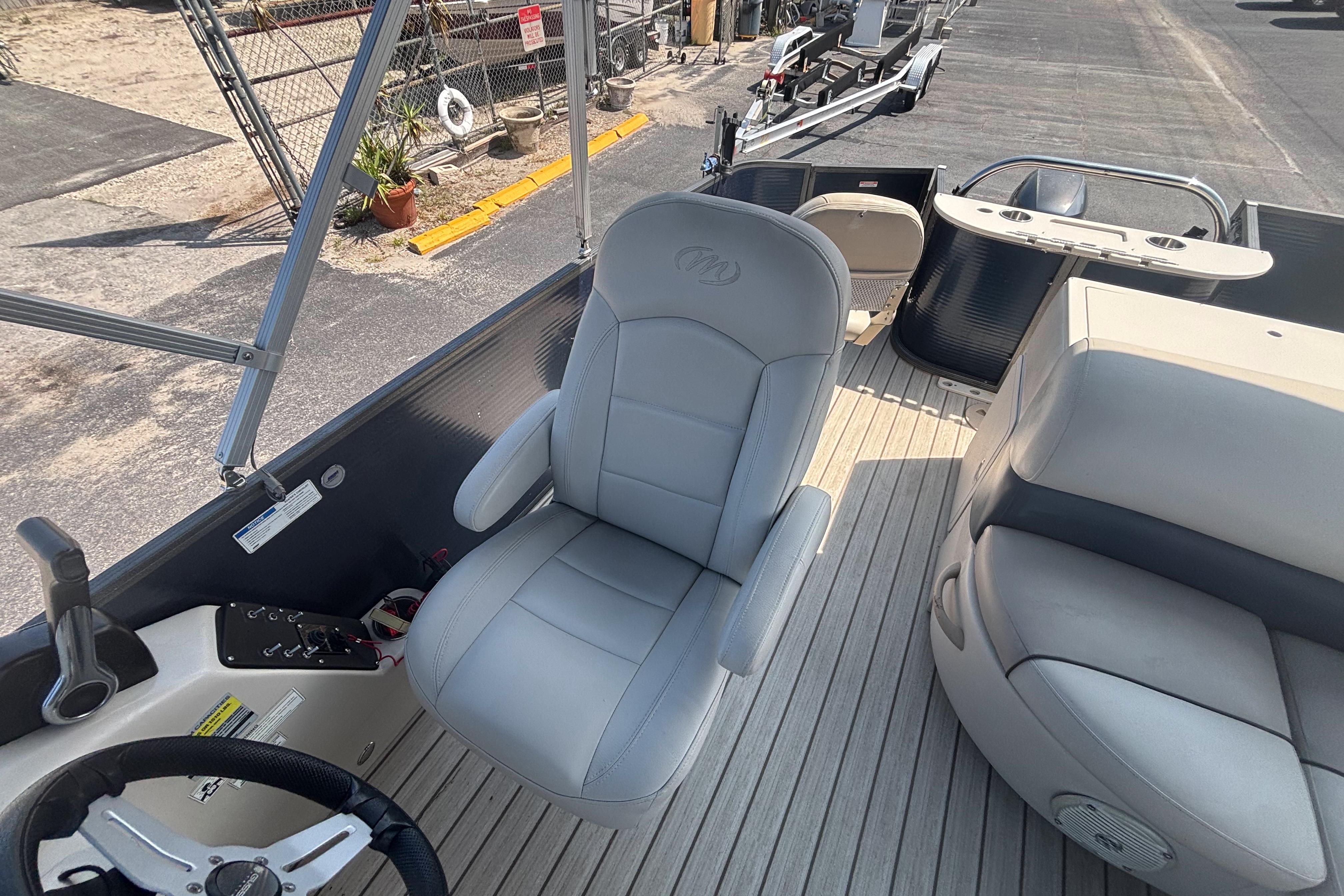 2015 Manitou 20 Oasis Angler boat interior with steering wheel and seating.