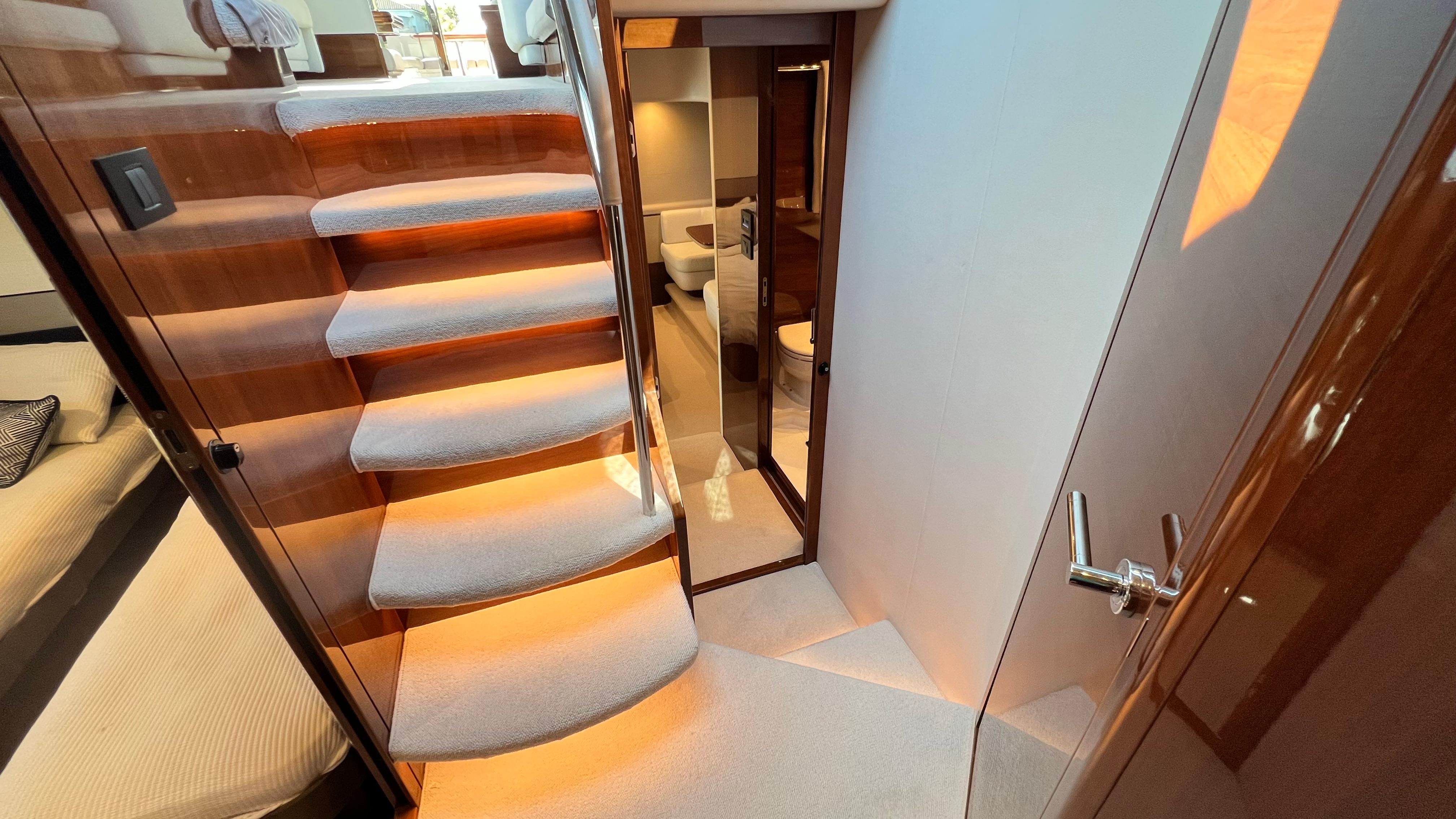 Luxurious interior of 2019 Princess F62 yacht with elegant staircase and modern design.