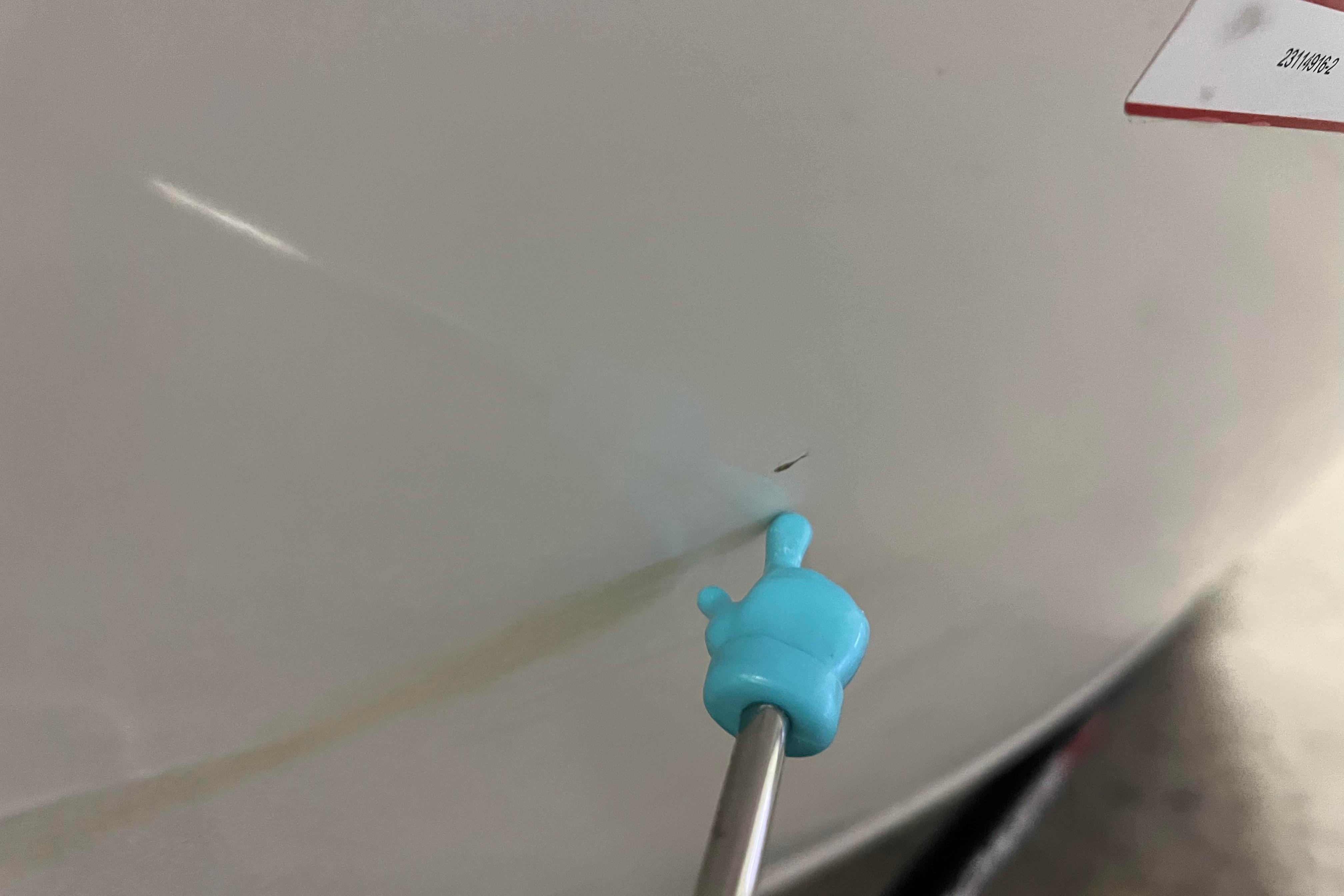 Close-up of a 2022 Tracker Pro Guide V-16 WT boat hull with a small scratch.