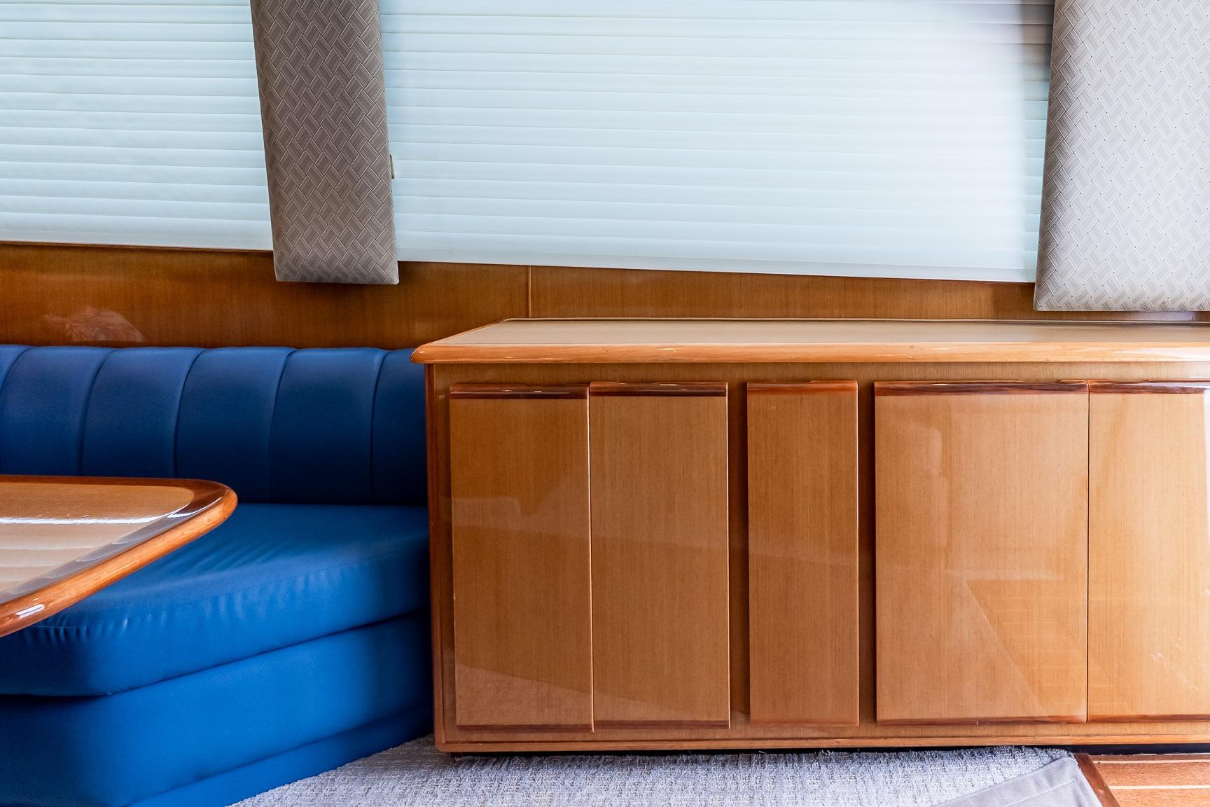 Interior of 2000 Viking 50' Convertible yacht with blue seating and wooden cabinetry.
