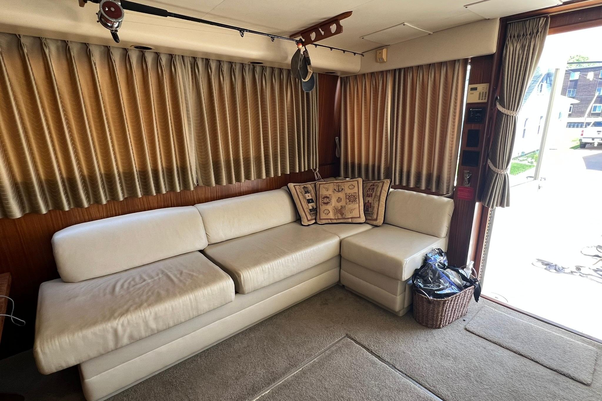 Luxurious interior of 1990 Hatteras 41 Convertible yacht with cream sofa and decorative pillows.