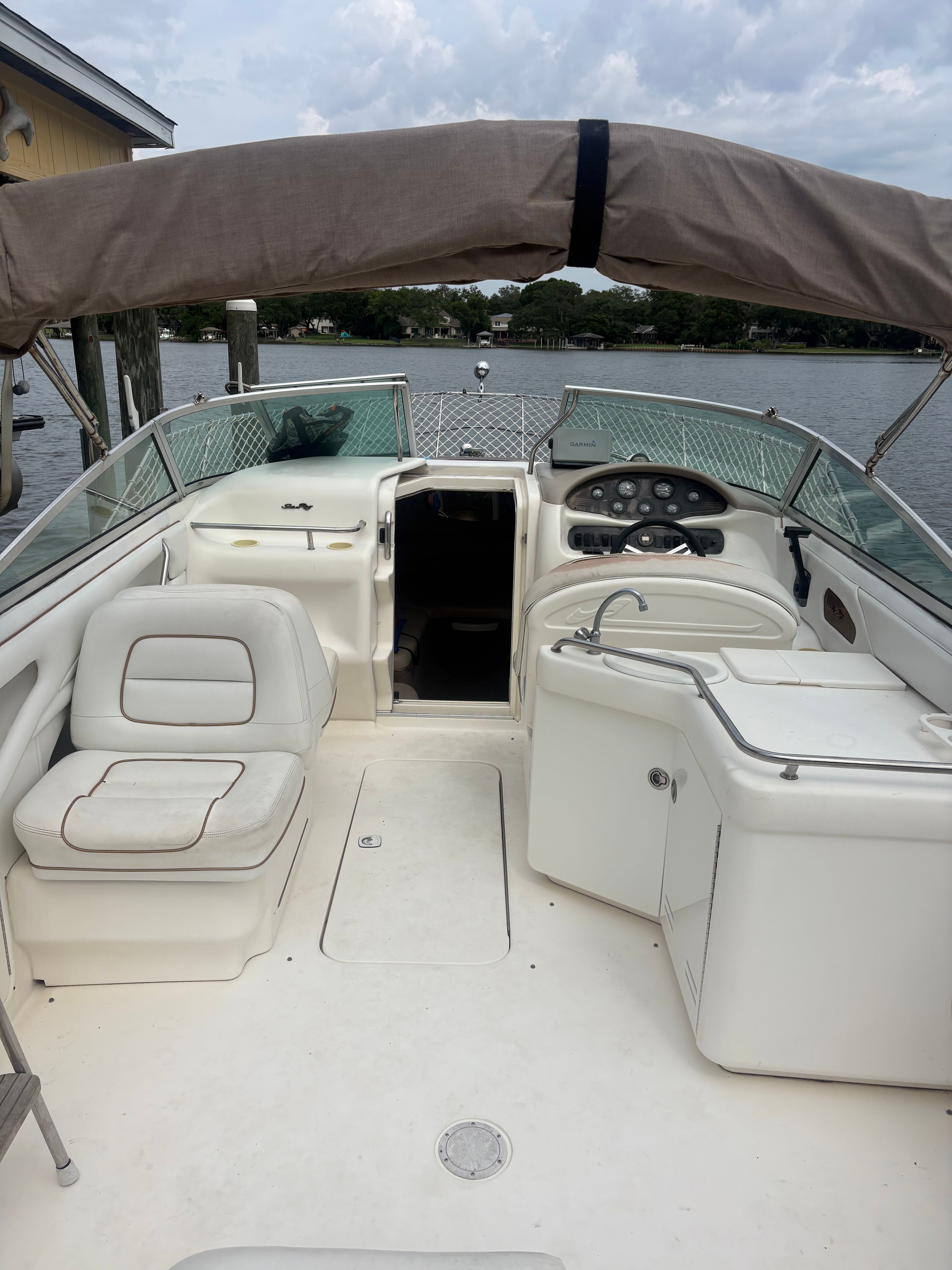 The image shows the cockpit of a 1996 Sea Ray 280 Cuddy Cabin with a beige canopy.