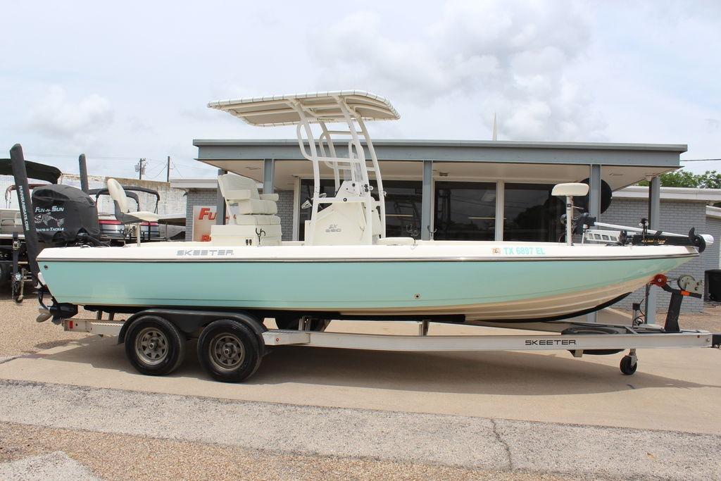 2026 Skeeter SX230 boat on trailer, parked outside a building.