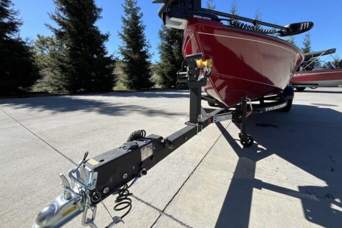2025 Tracker Super Guide V-16 T boat on trailer, parked outdoors.