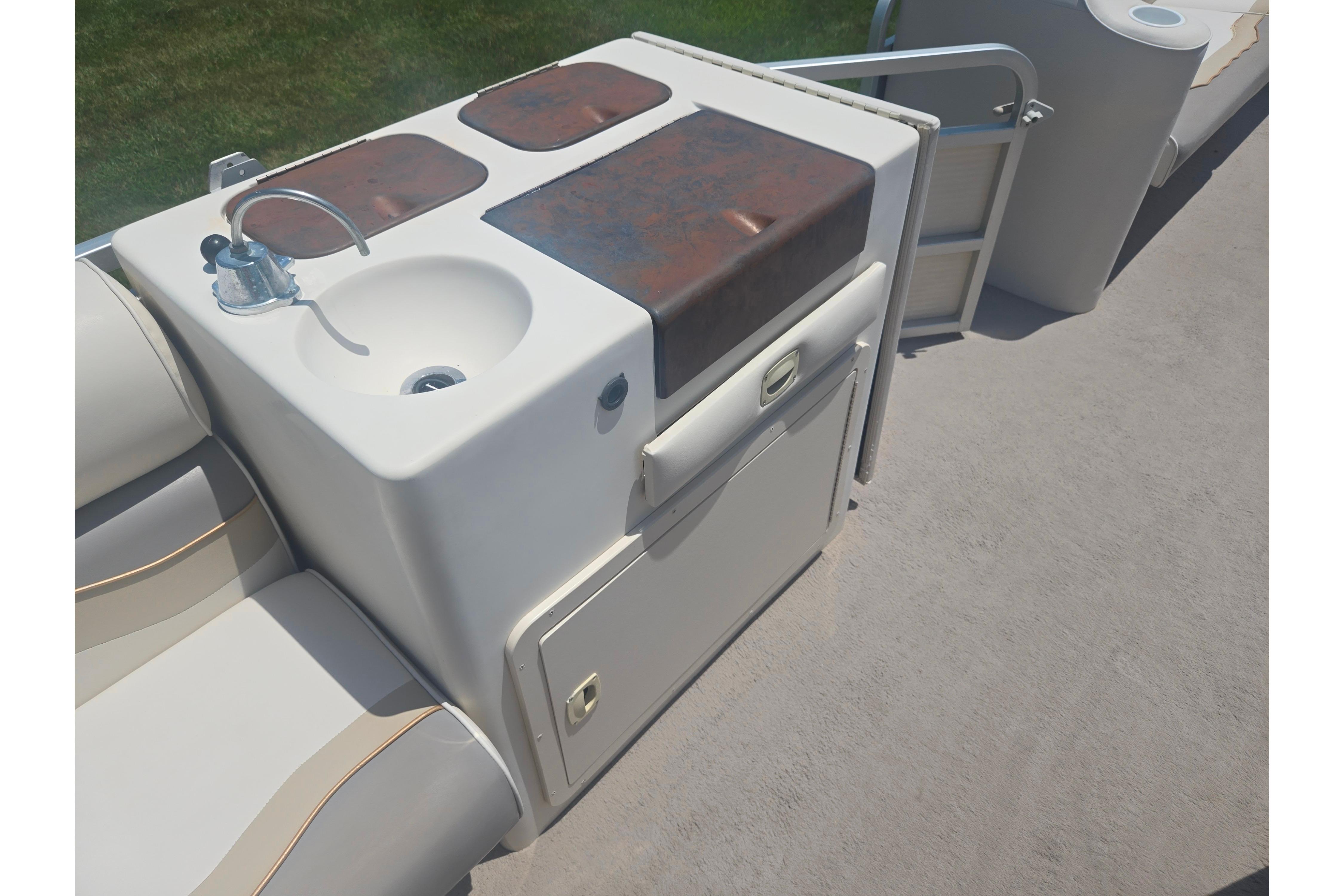 Pontoon boat interior with sink and storage, Sylvan 824 Elite Cruise, 2000 model.