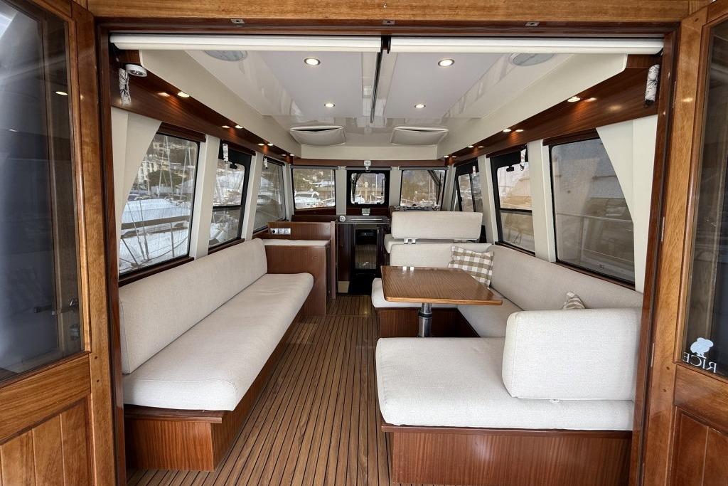 Interior of 2012 Sasga Yachts Menorquin 42 with elegant wood and beige seating.