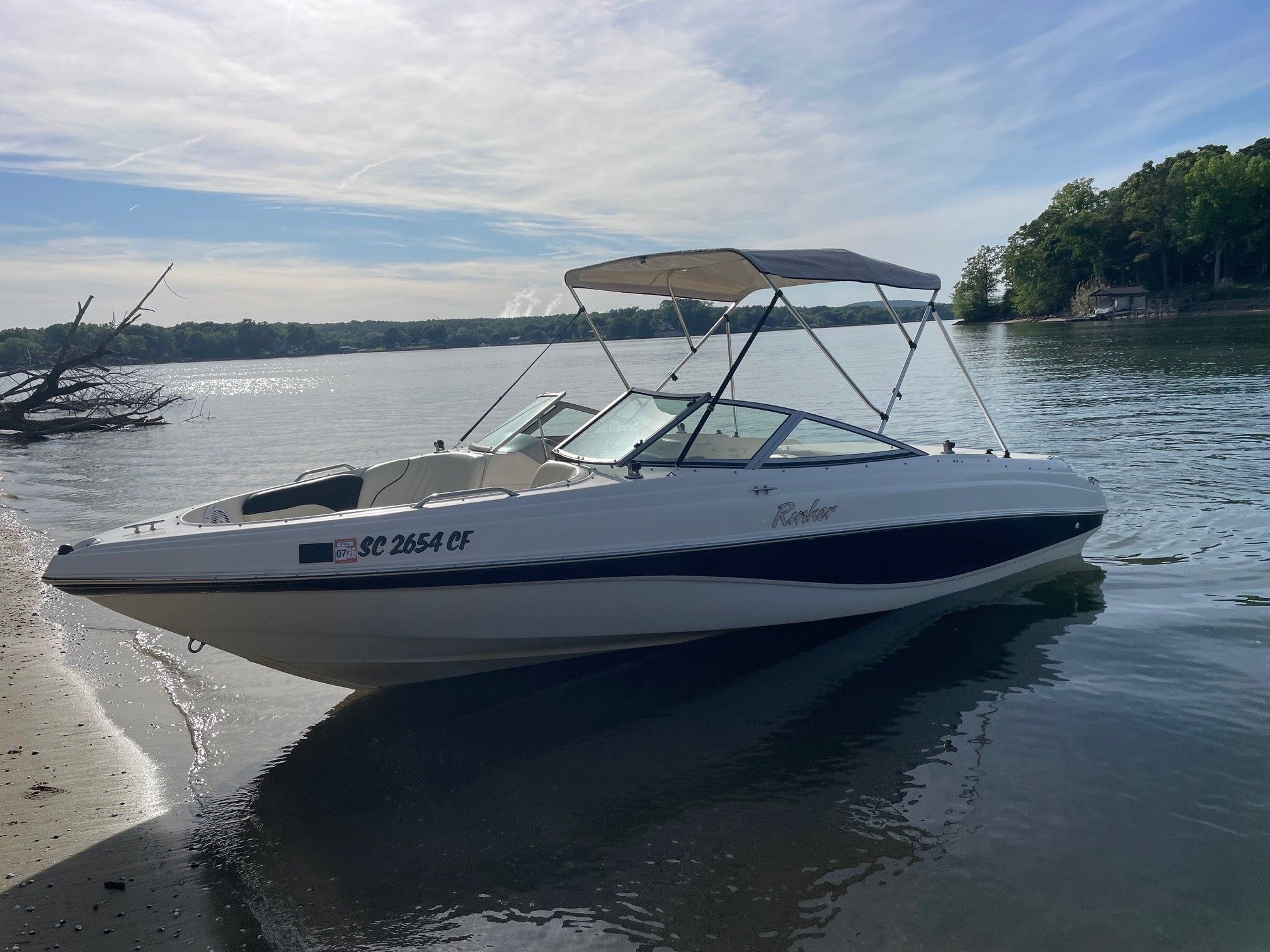 2002 Rinker 212 Captiva Bowrider at a serene lakeside.