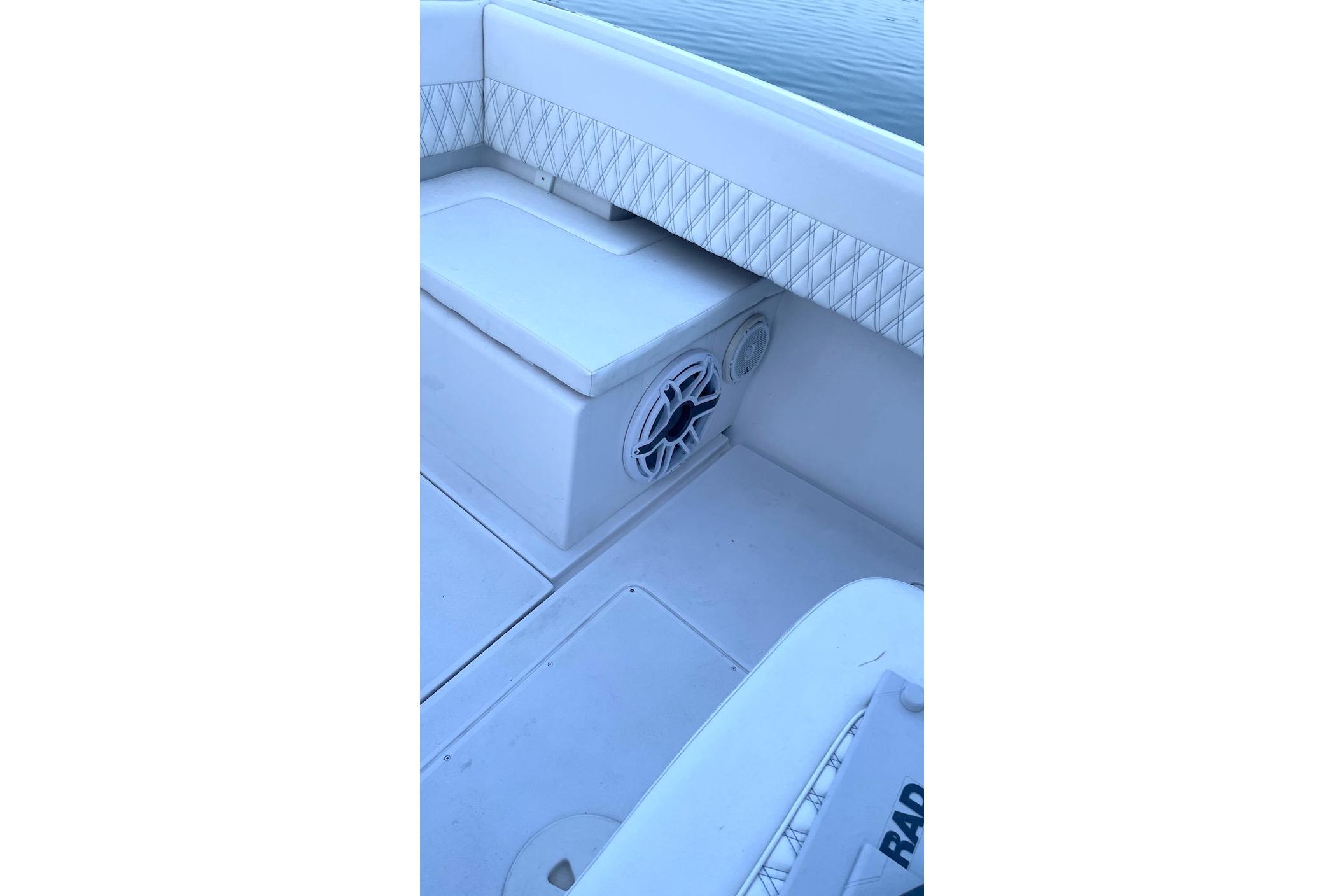 2002 Intrepid 323 Cuddy boat interior with cushioned seating and speaker detail.