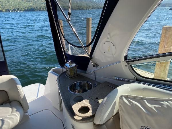The boat features a small kitchenette with a sink and cup holder, surrounded by water.