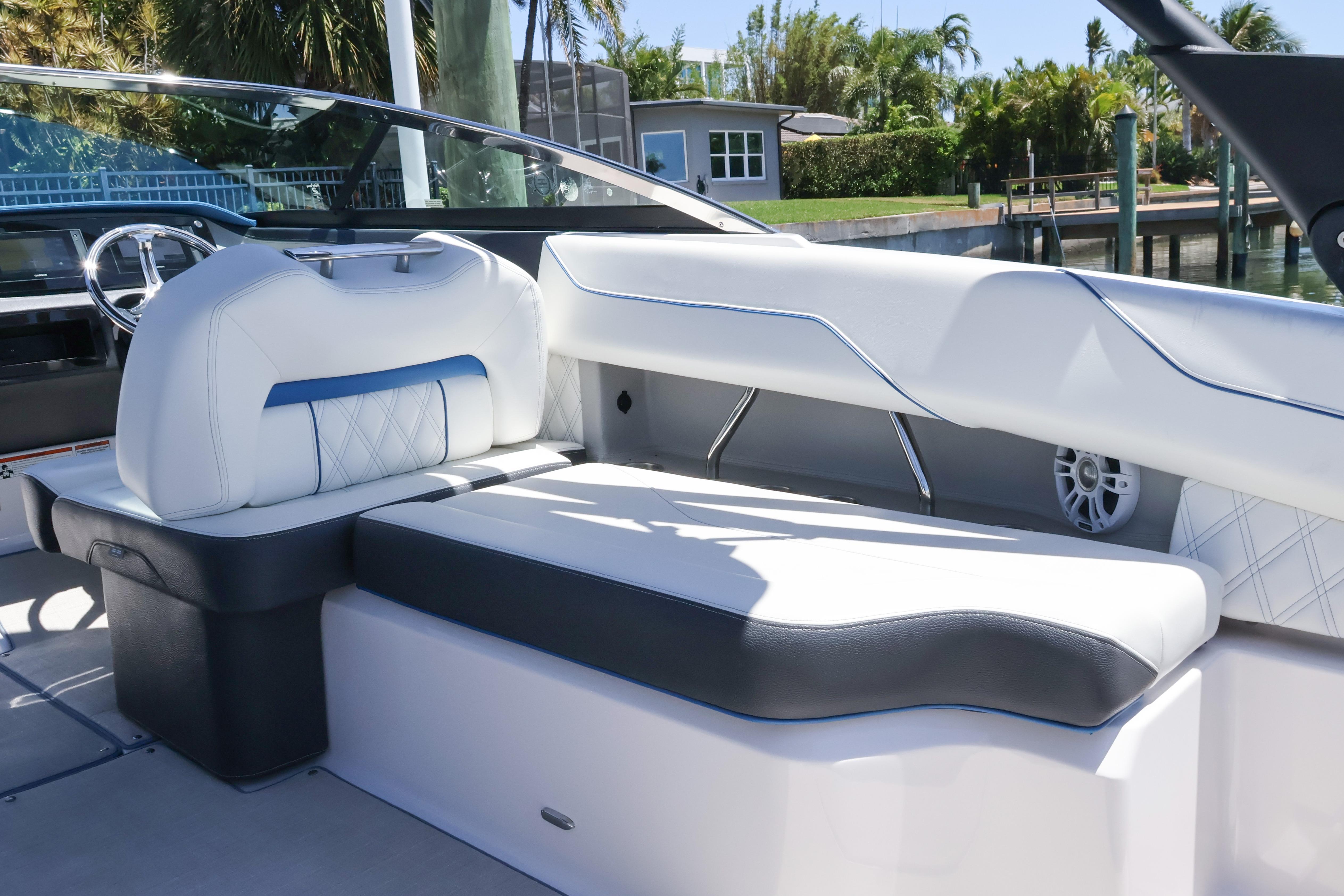2020 Regal LX4 boat interior with white and blue seating, docked near lush greenery.
