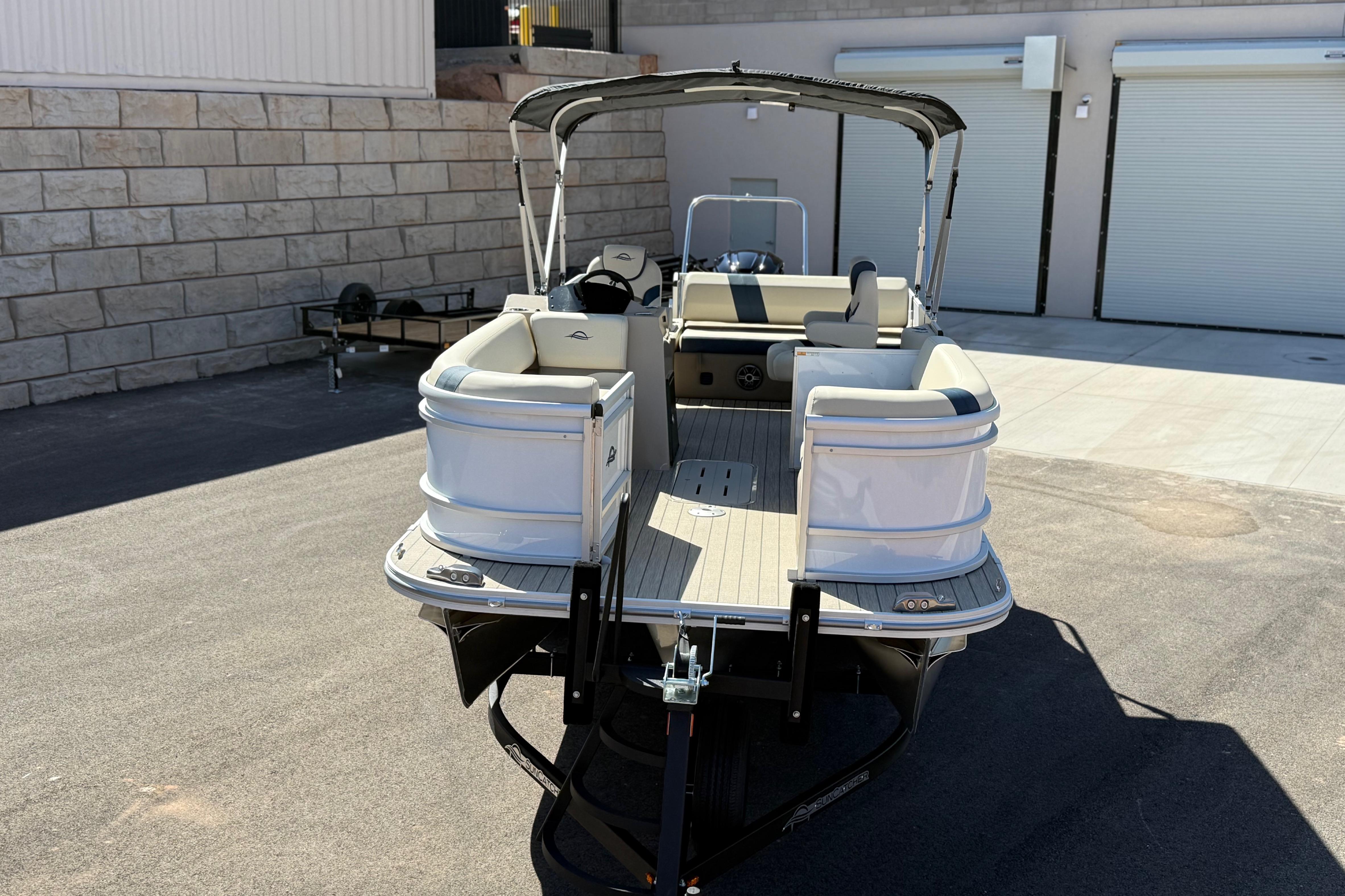 2026 SunCatcher Select 322SL pontoon boat parked on pavement near storage facility.