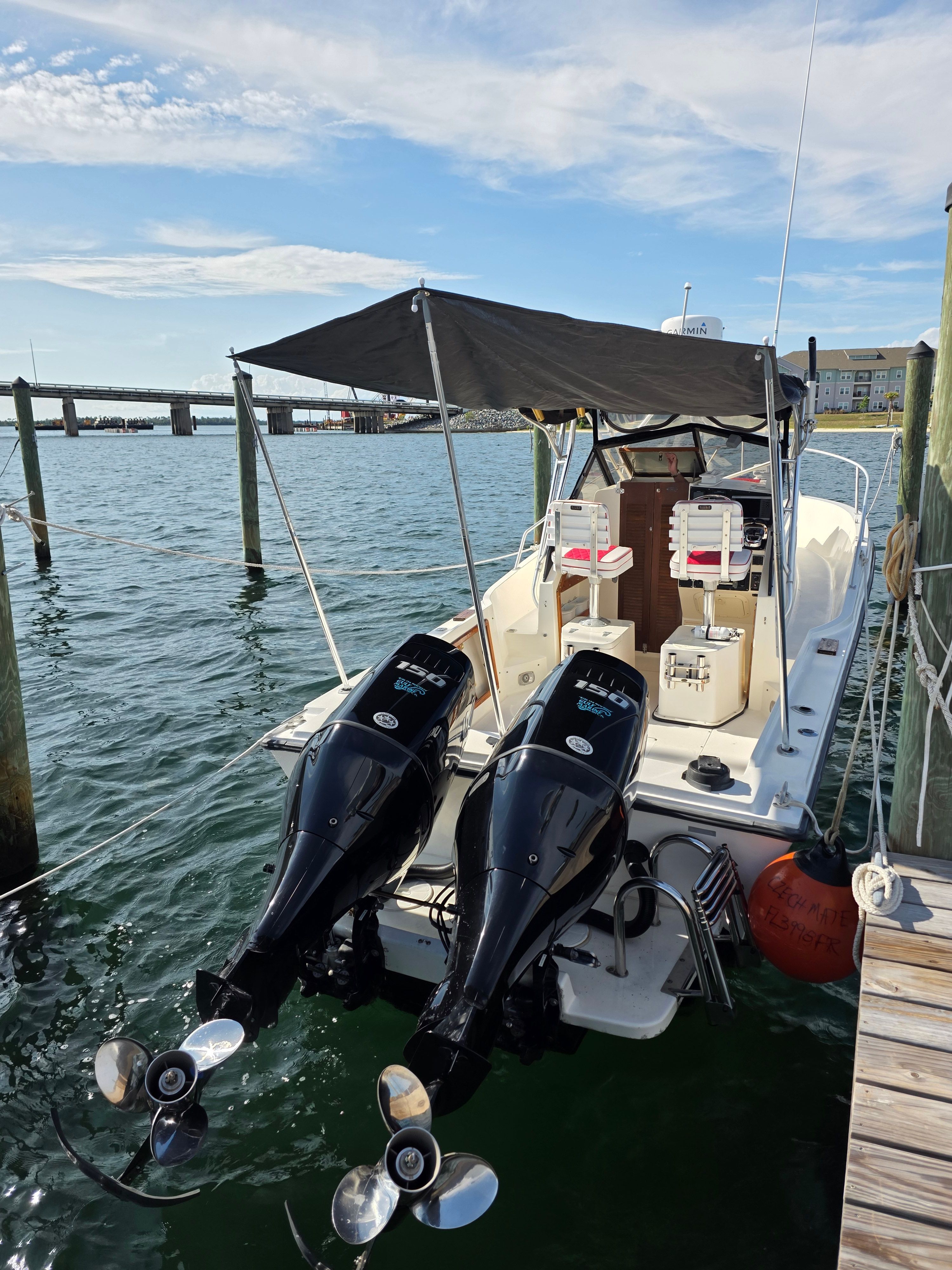1987 Mako 248 WAC boat with twin outboard motors at dock.