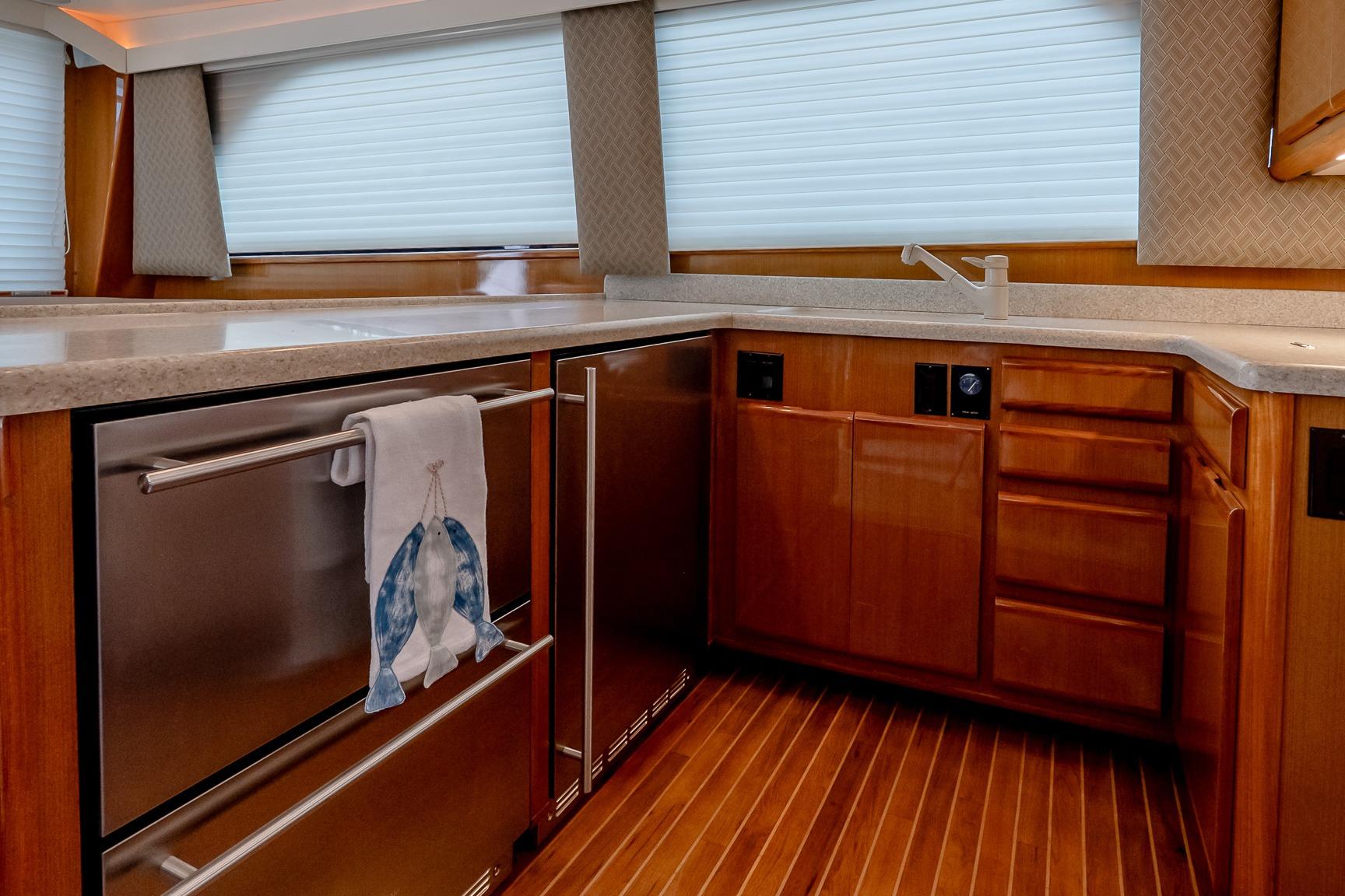 Luxurious kitchen interior of 2000 Viking 50' Convertible yacht with wood cabinetry and modern appliances.