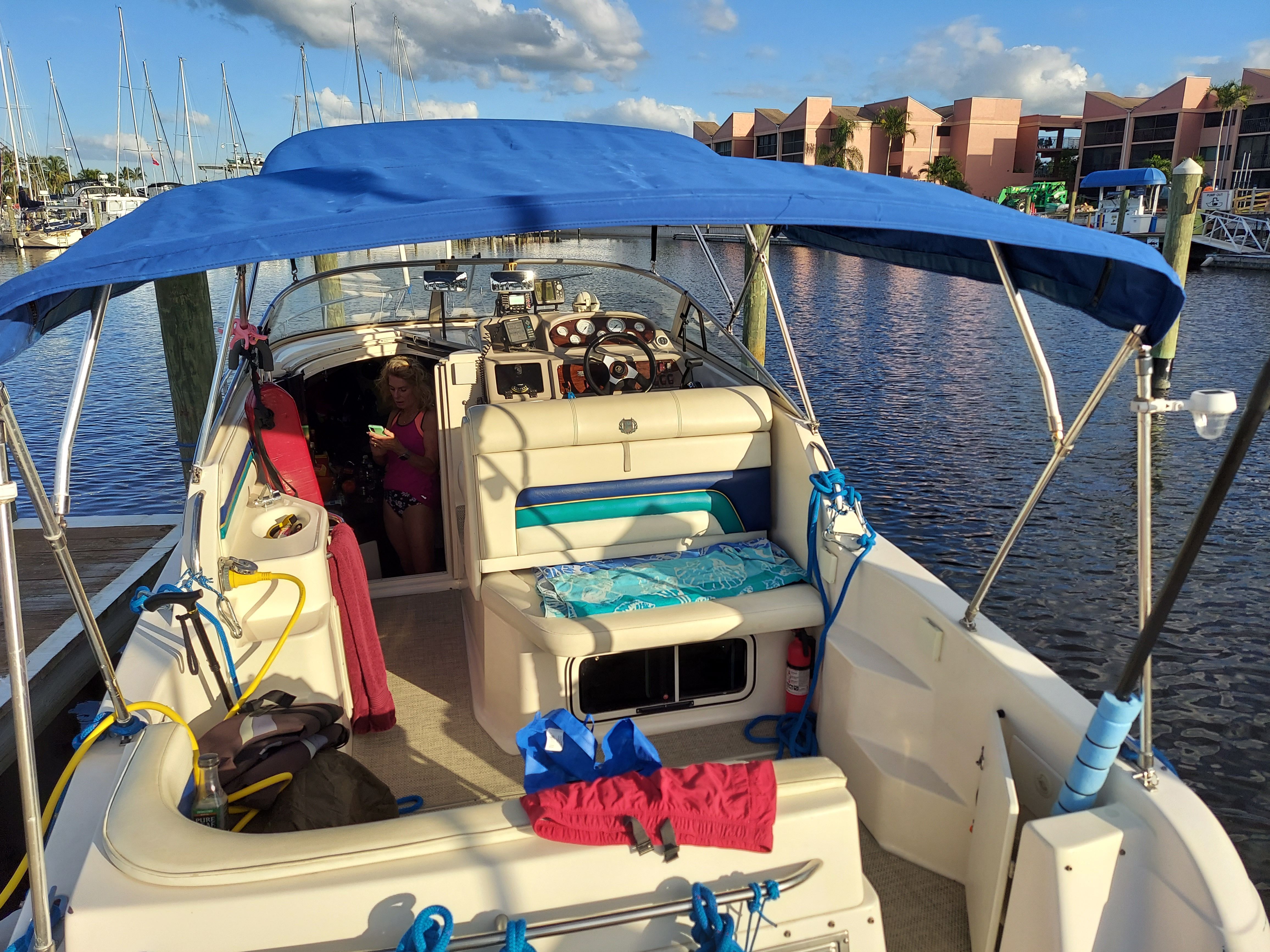 1997 Donzi 275LXC boat docked with blue canopy.
