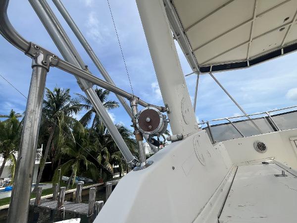 1985 Hatteras 45 Convertible yacht deck with palm trees and blue sky.
