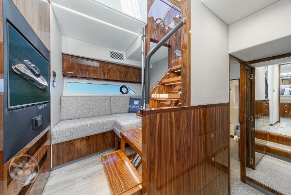 Luxurious interior of 2025 Riviera 645 SUV yacht with modern wood finishes and cozy seating area.