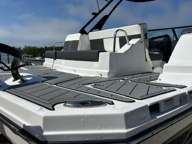The boat features a modern design with gray upholstery and an open deck.