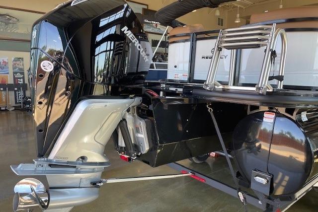 2026 Regency 230 DL boat with Mercury outboard motor in showroom.