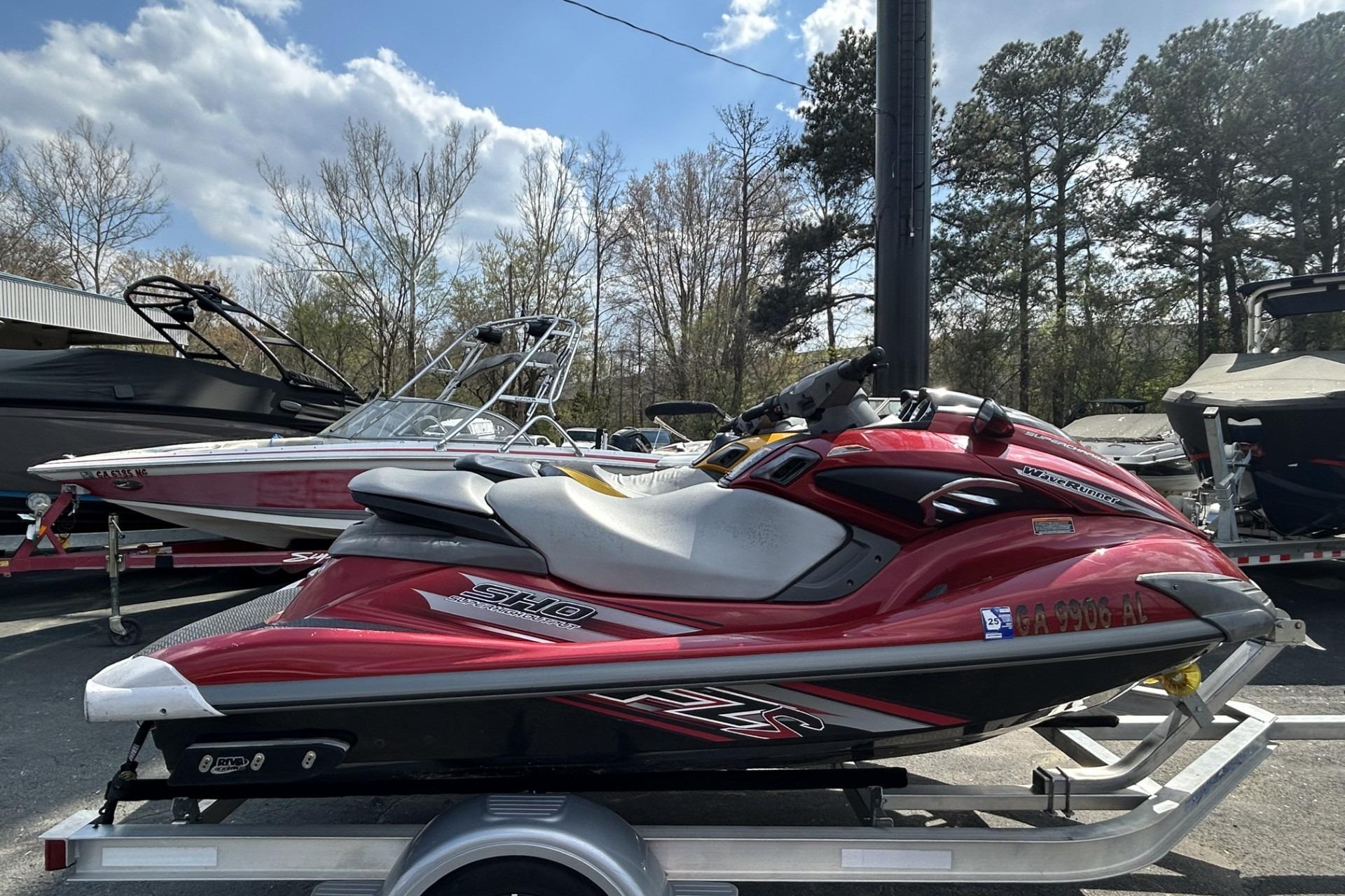 2011 Yamaha WaveRunner FZS in red, parked on a trailer, with boats in the background.