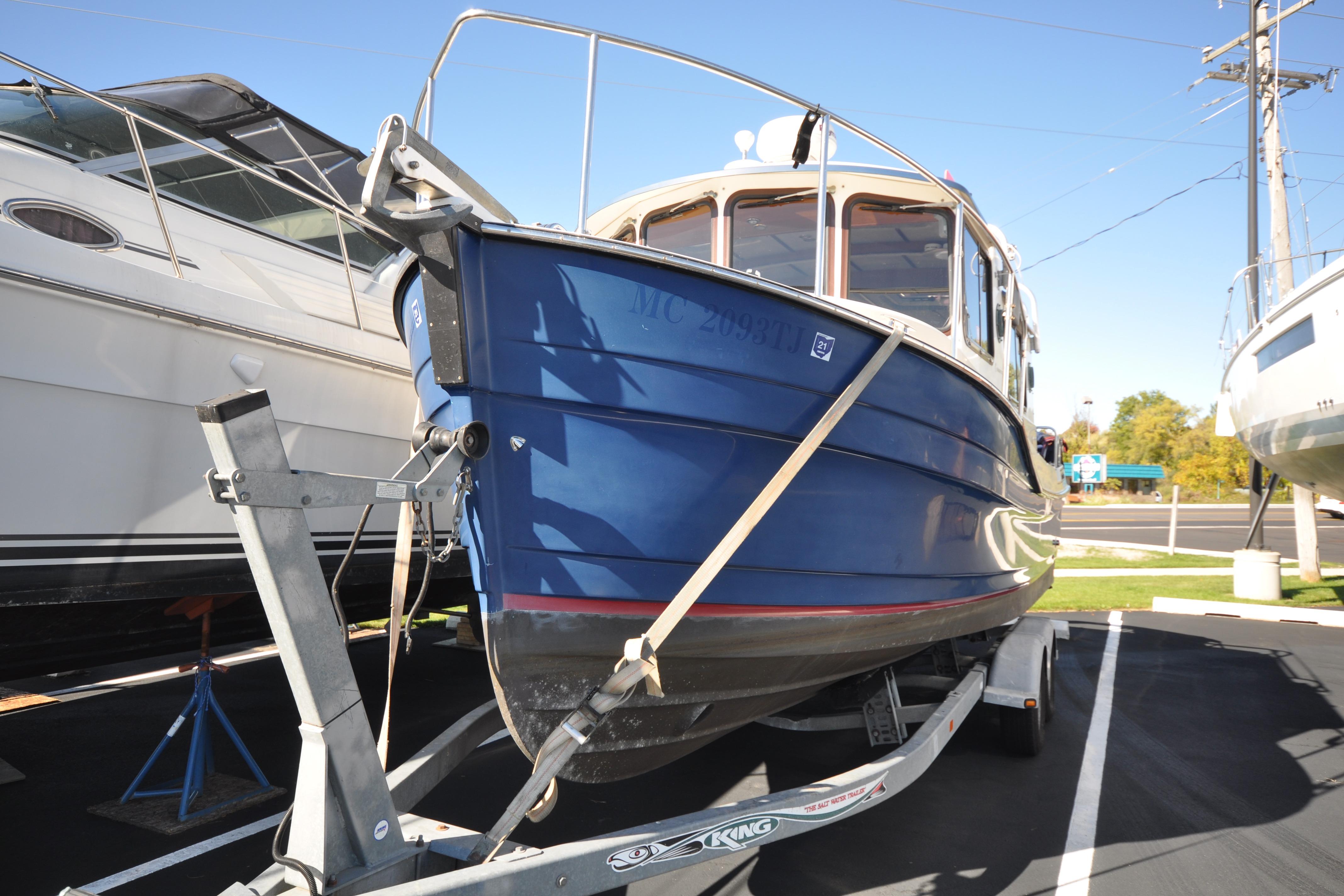 2007 Ranger Tug R-25 boat on trailer in a parking lot.