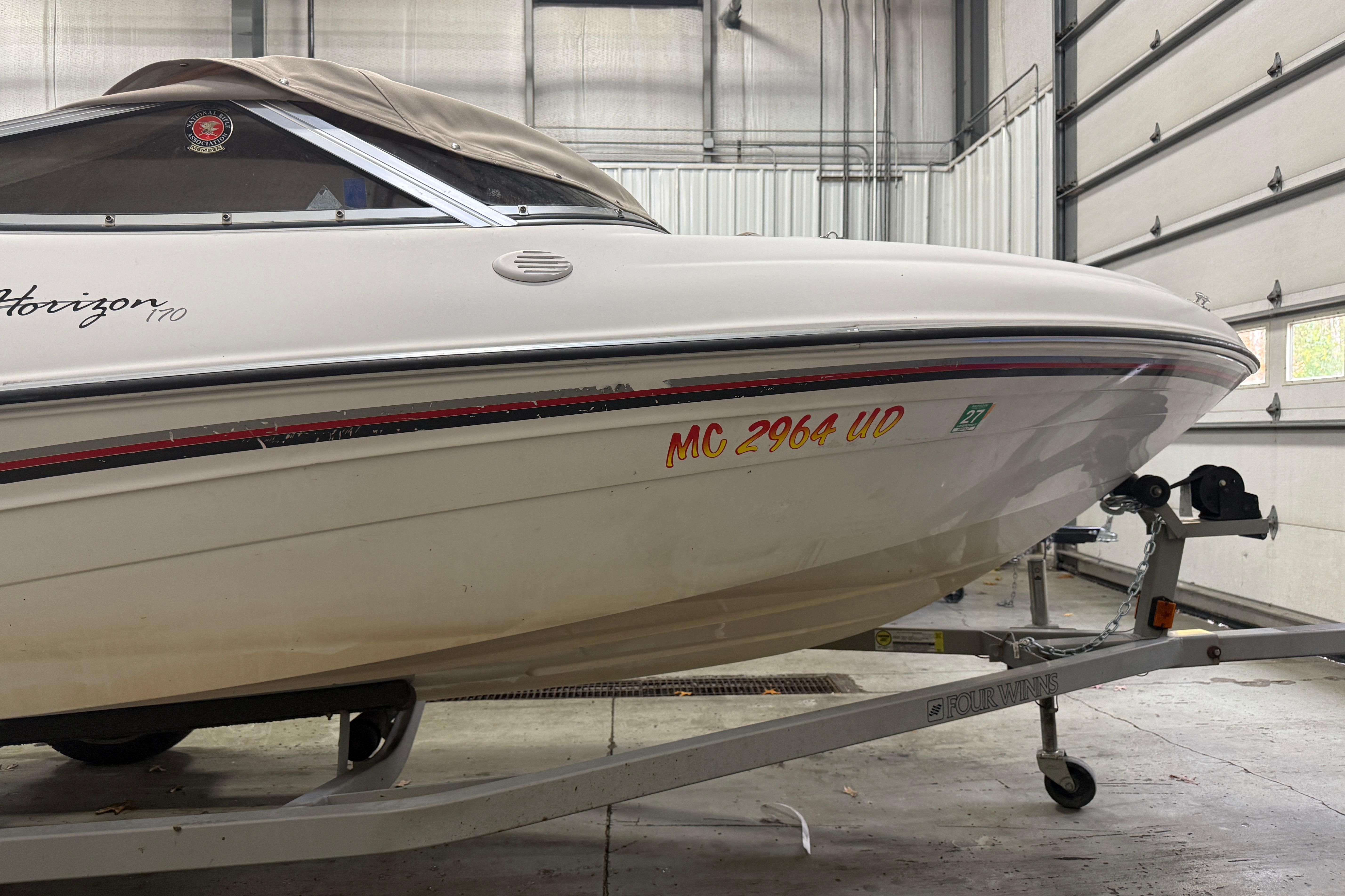 1999 Four Winns 170 Horizon LE boat on trailer in garage.