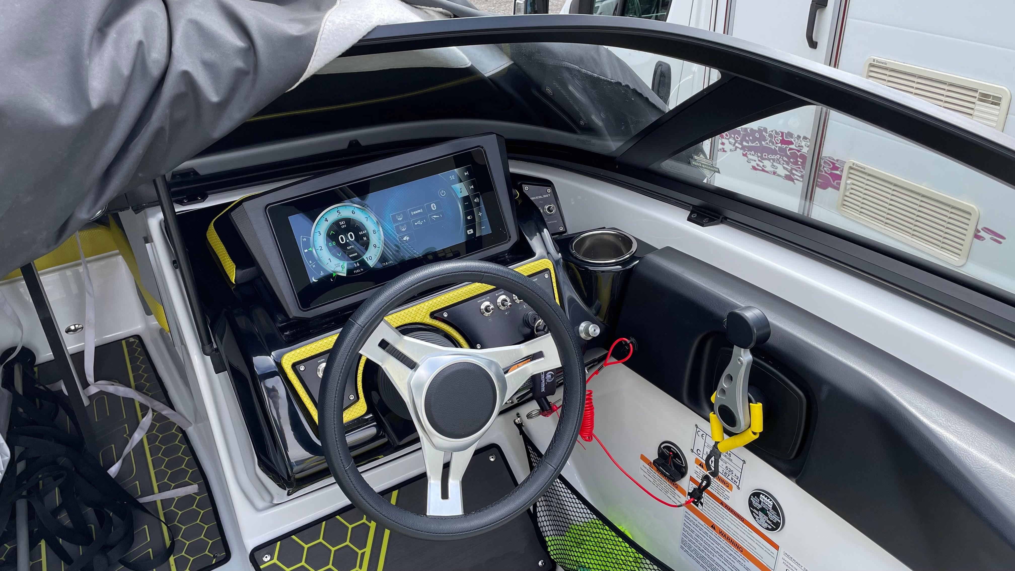 2021 Scarab 195 ID boat dashboard with steering wheel and digital display.