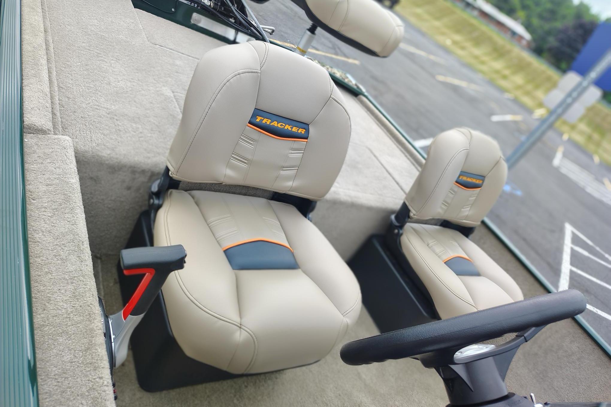2026 Tracker Bass Tracker Classic Limited boat seats, beige with orange accents, in a parking lot.