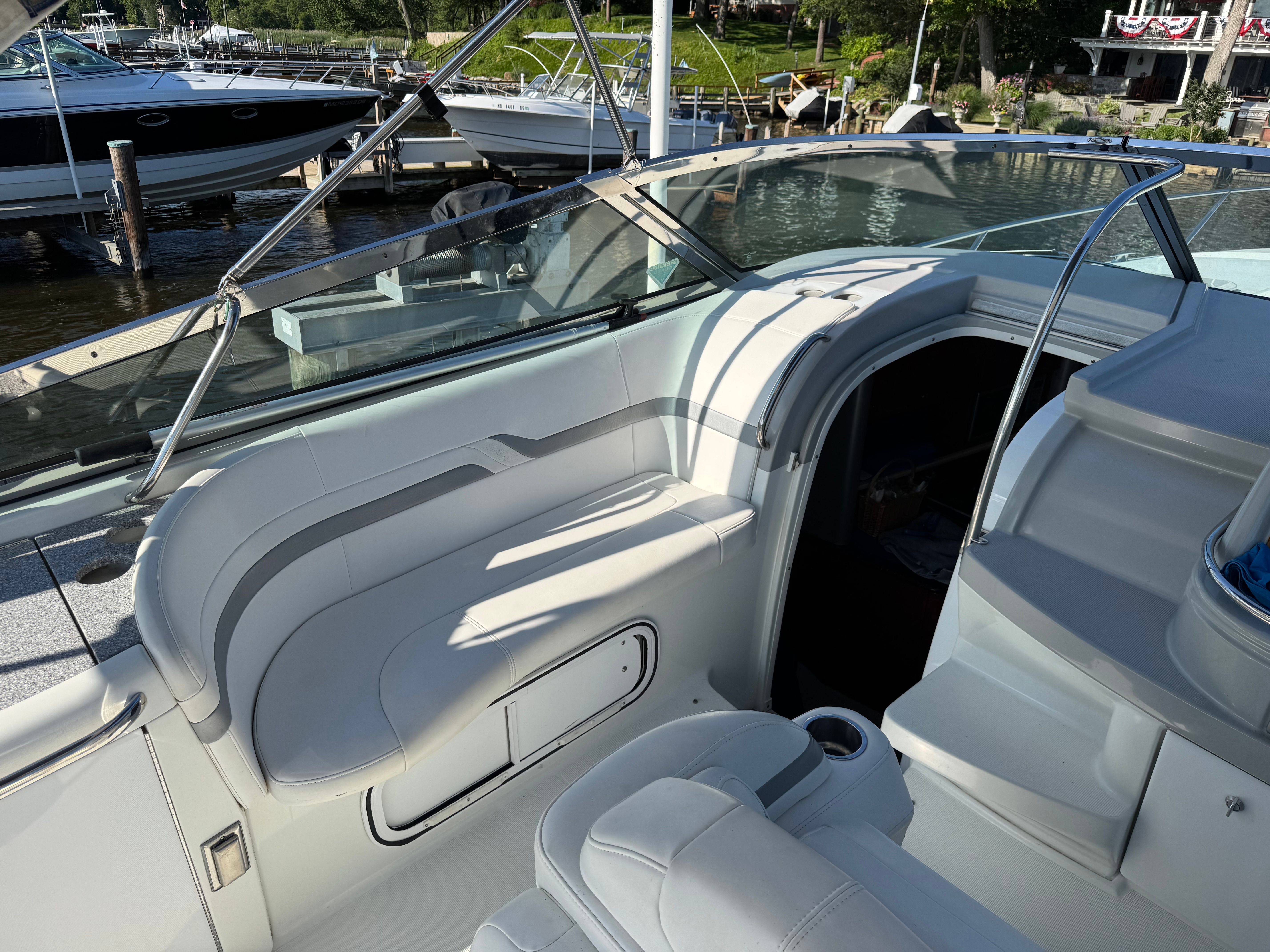 The image shows a boat's cockpit with white seating and an open entryway.