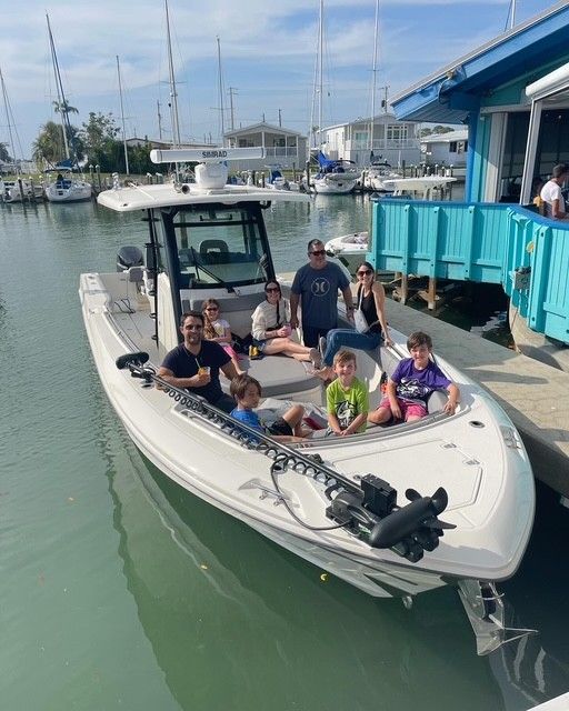 Family on a 2023 Boston Whaler 330 Outrage boat at the harbor.