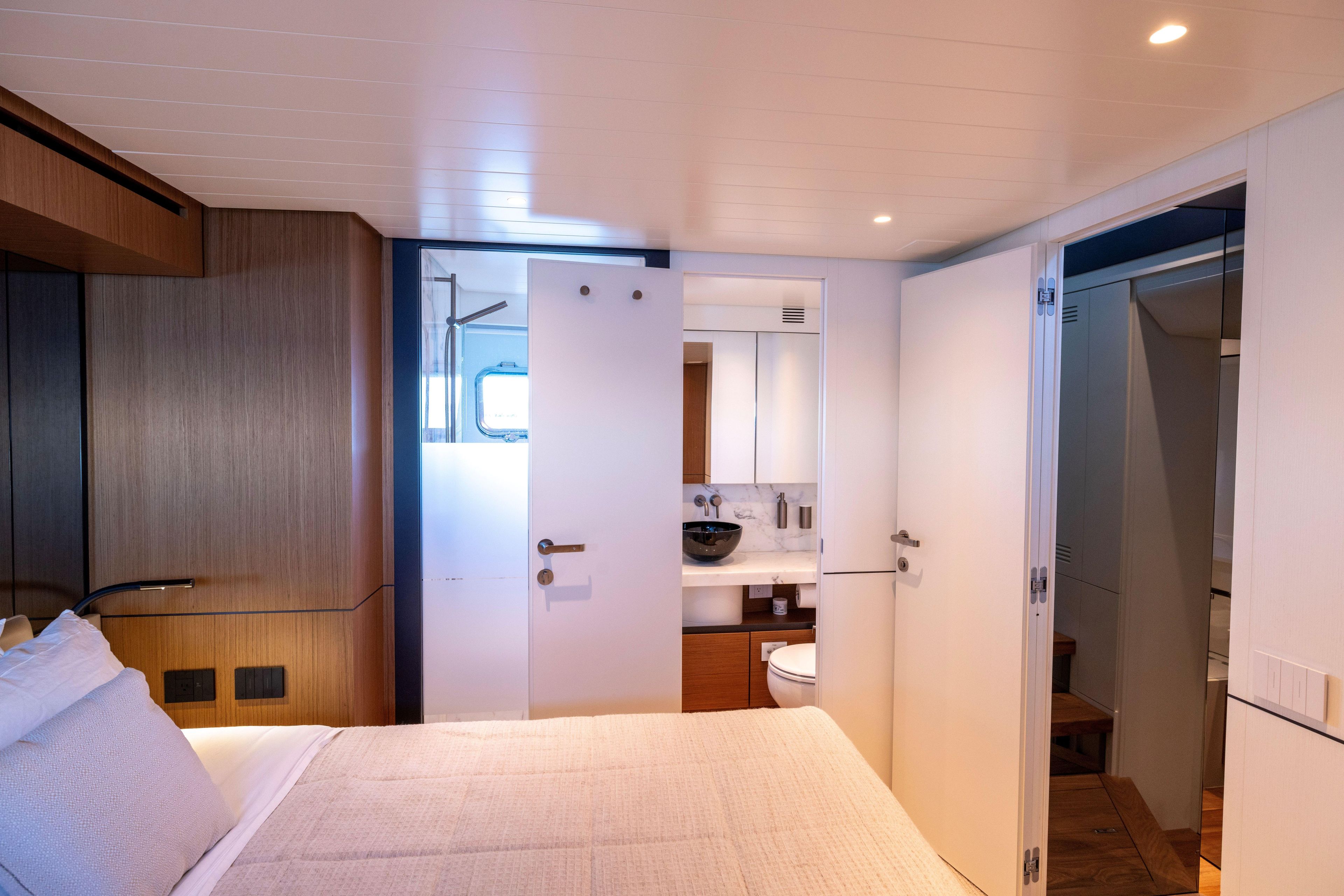 Luxurious interior of 2024 Bluegame BGX63 yacht featuring a modern bedroom and bathroom.