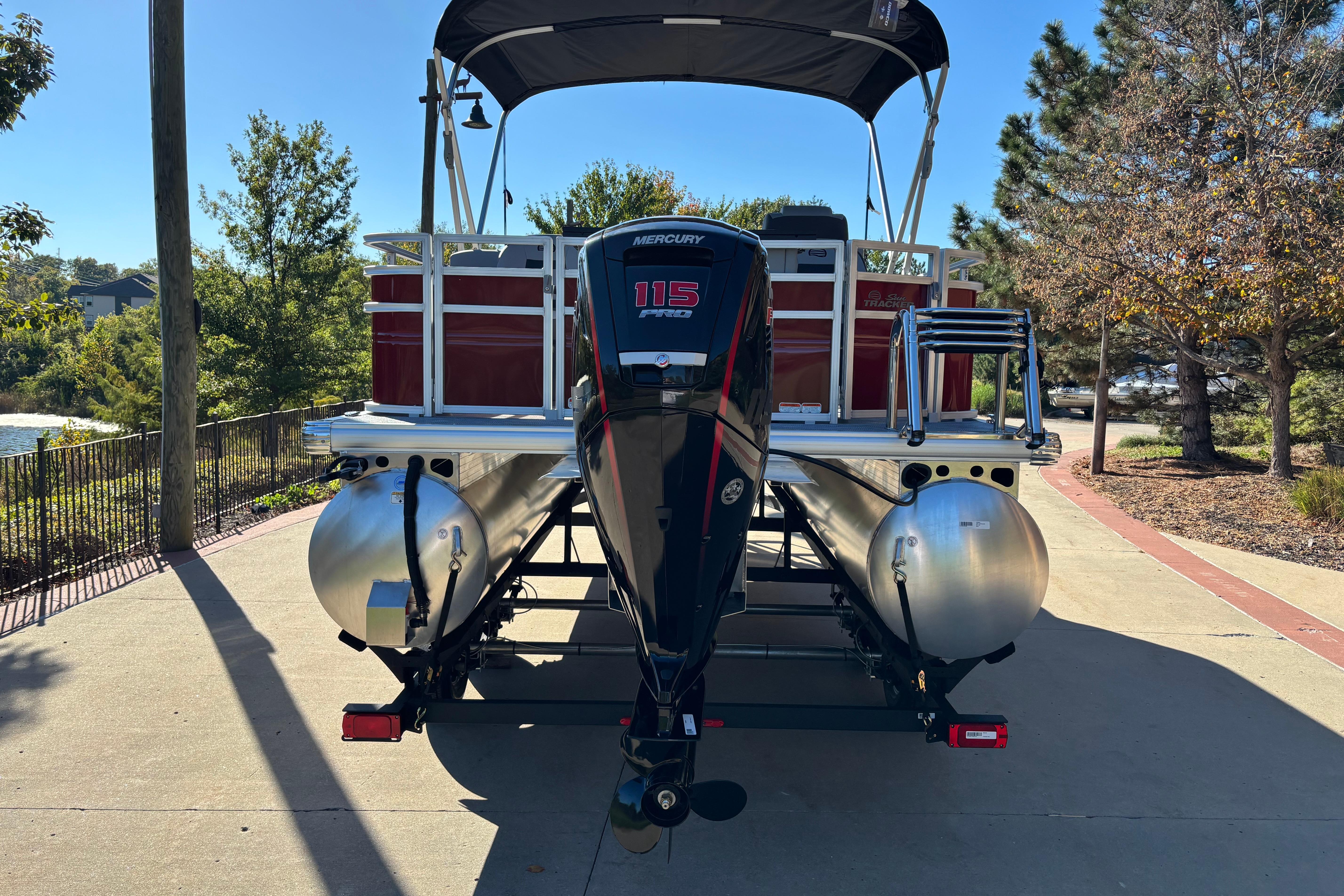 2026 Sun Tracker SportFish 20 DLX pontoon boat with Mercury 115 engine on trailer.