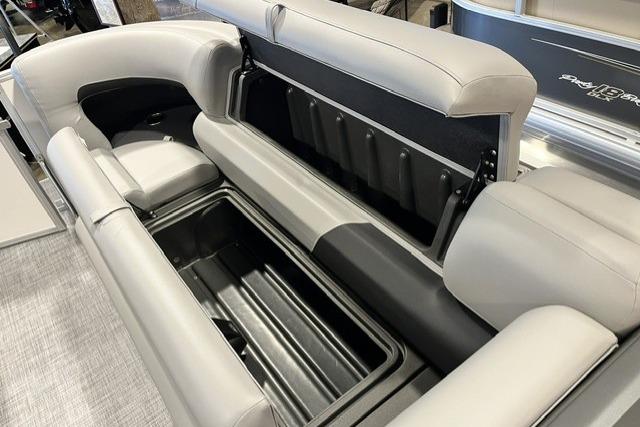 2026 Sun Tracker Party Barge 20 DLX pontoon boat with open storage compartment and cushioned seating.