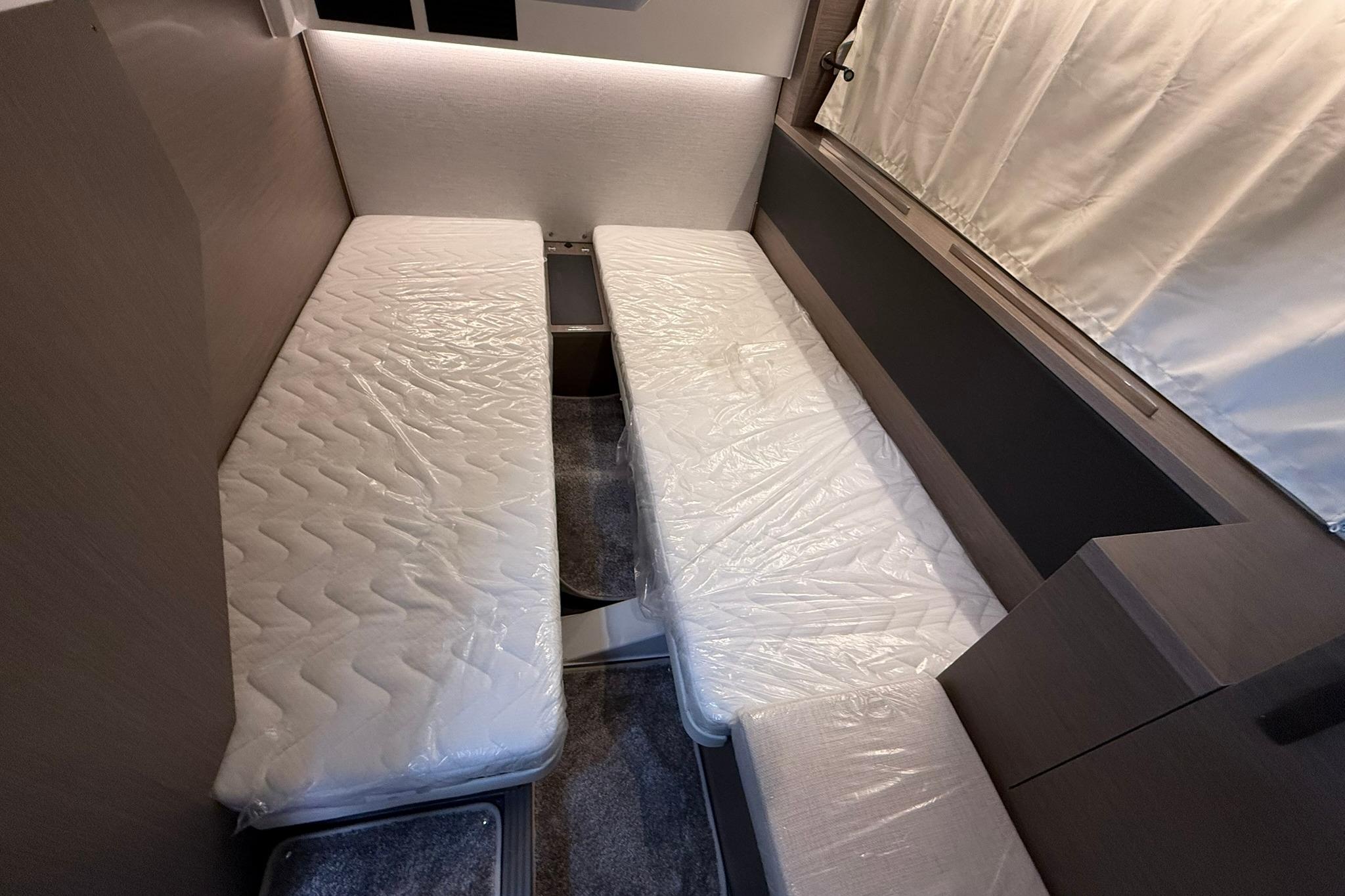 Interior cabin of 2026 Jeanneau NC 1295 Coupe with twin beds and modern design.