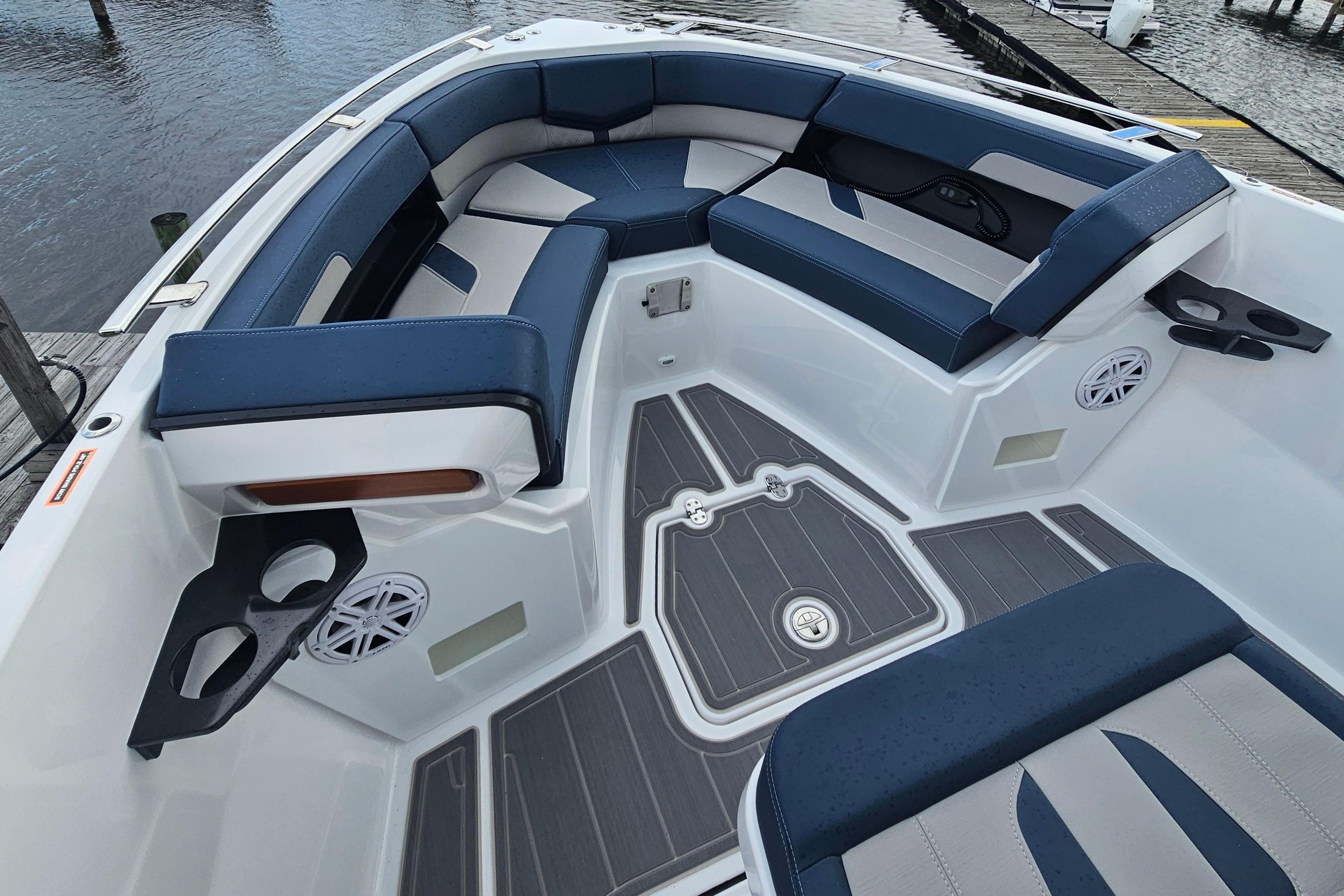 Luxurious seating area on 2026 Monterey Elite 27 OB boat, featuring cup holders and speakers.