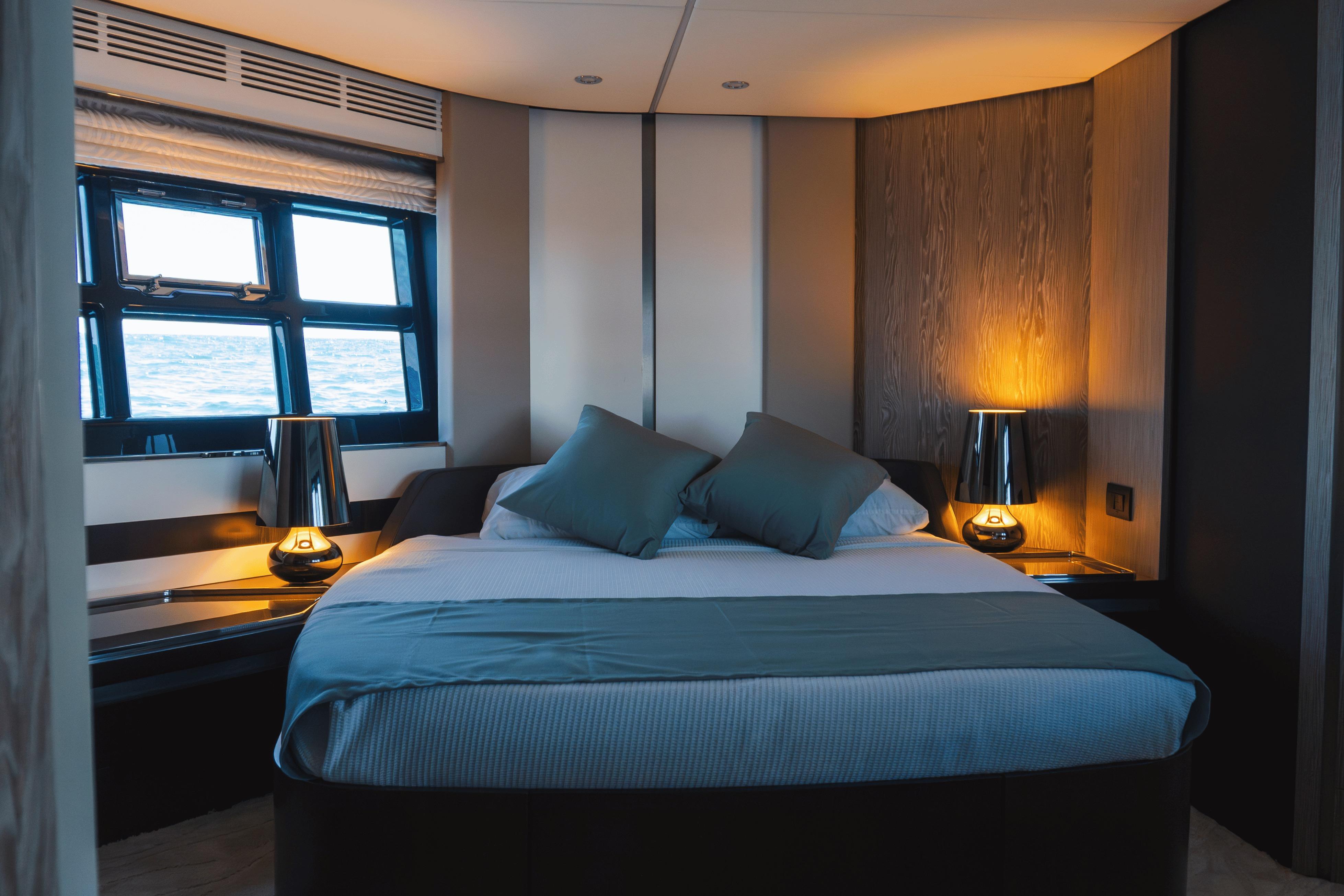 Luxurious bedroom interior of 2020 Azimut 60 yacht with ocean view windows.