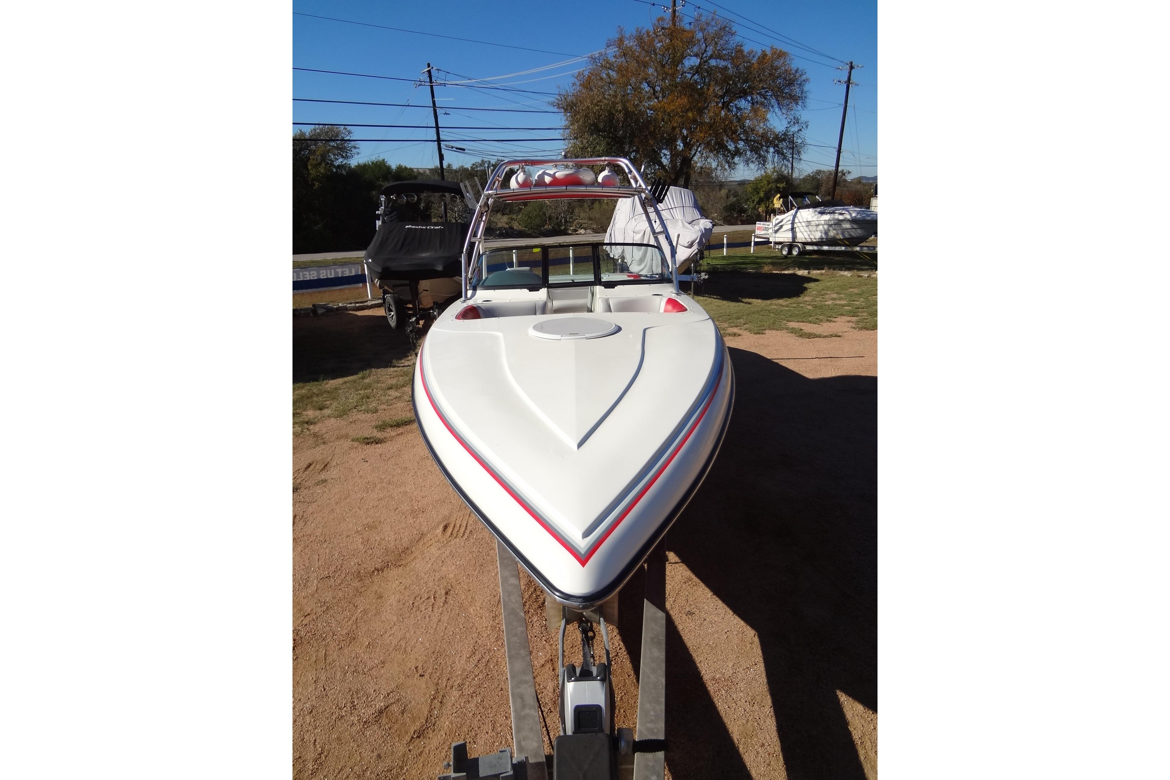 2003 Ski Centurion Tsunami boat on trailer, parked outdoors, clear sky background.