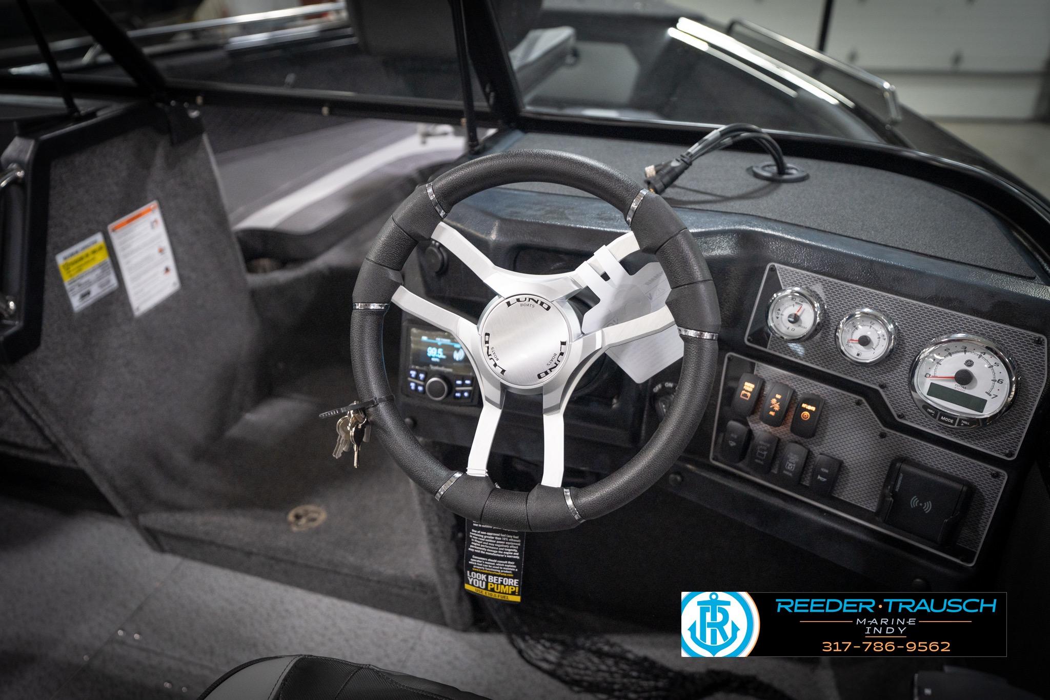 Steering wheel and dashboard of 2026 Lund 2275 Baron boat, featuring gauges and controls.