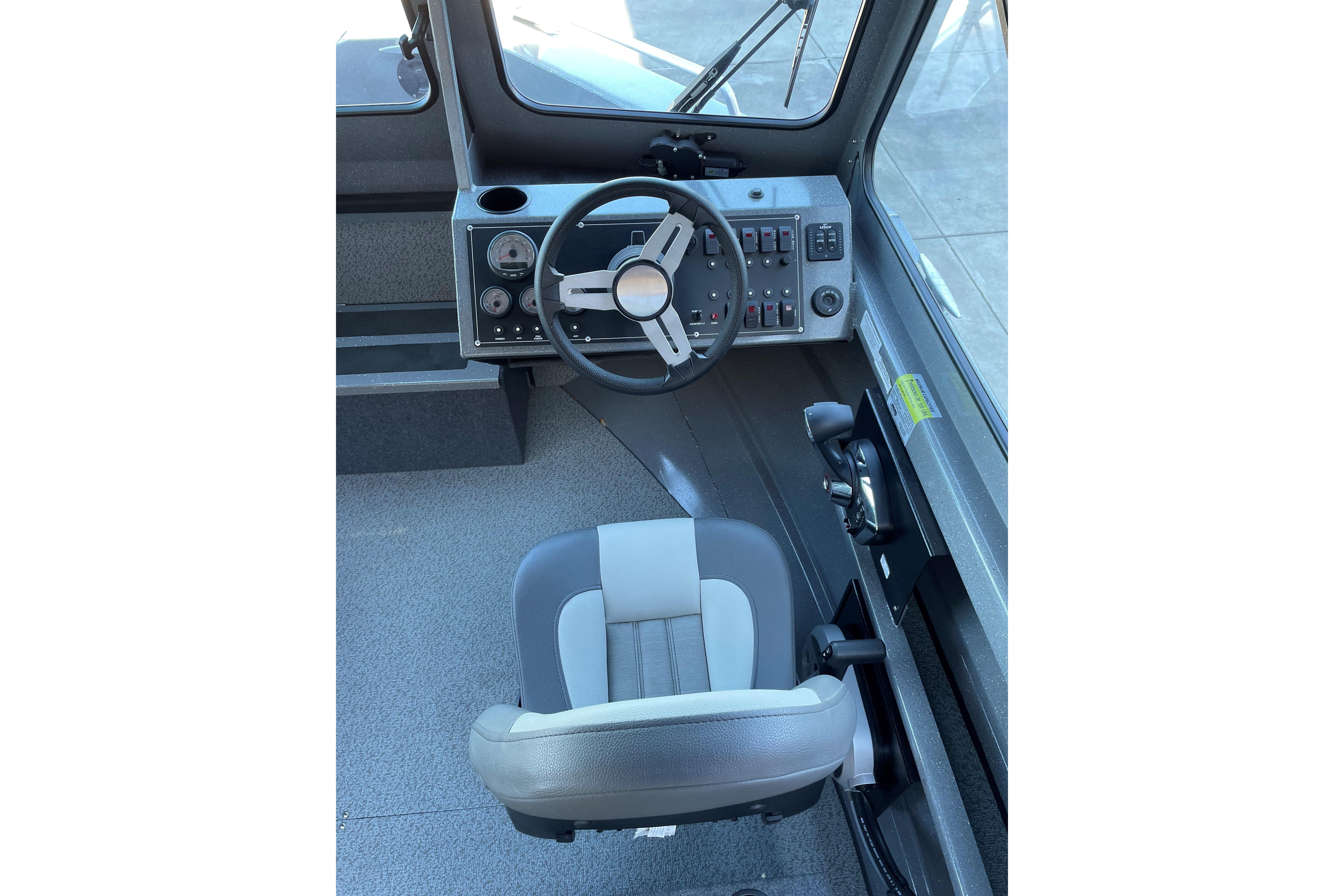 Interior cockpit of 2025 Spartan 200 Astoria boat with steering wheel and controls.