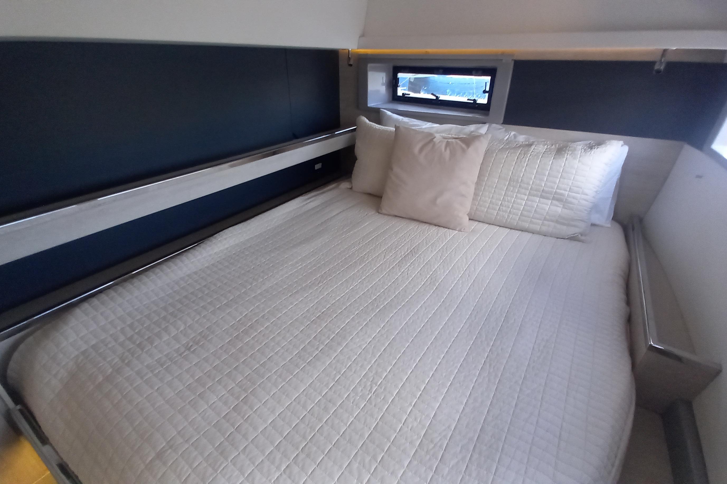 Cozy bedroom in a 2019 Leopard 45 yacht with a neatly made bed.
