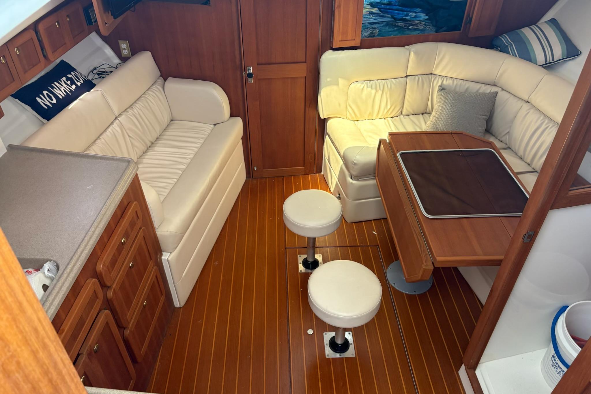 2008 Stamas 370 Express cabin interior with wooden flooring and white leather seating.