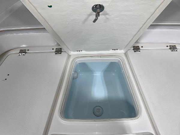 2026 Robalo 226 Cayman boat storage compartment with open lid, showcasing interior space.