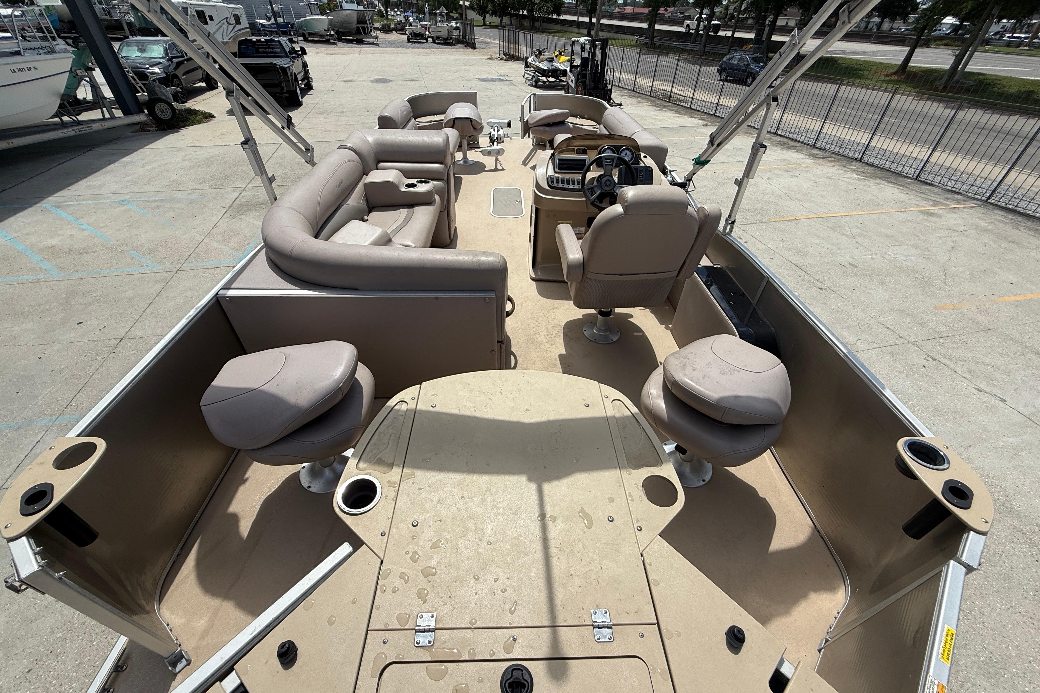 2014 Godfrey Sweetwater 2486 C pontoon boat with spacious seating and helm, docked outdoors.