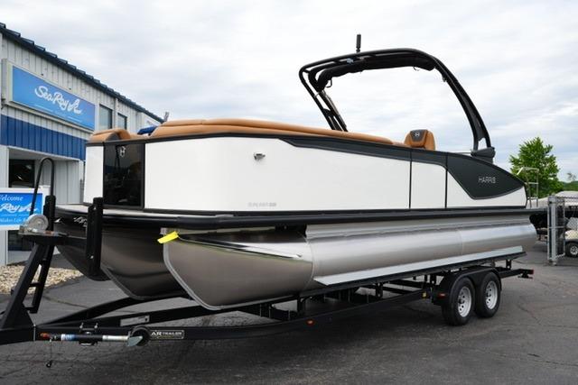 2026 Harris Sunliner 250 Sport pontoon boat on trailer, parked outside dealership.